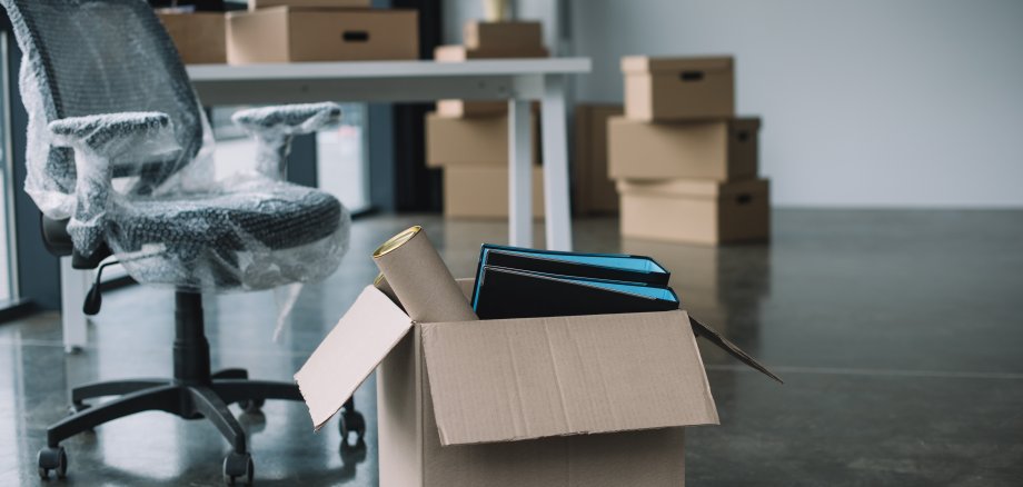 cardboard box with folders and office supplies in floor during r