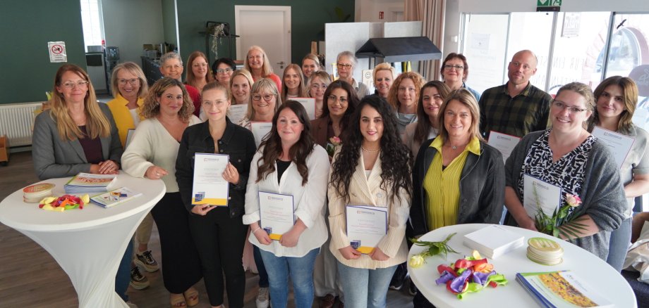 Absolventen des letzten Qualifizierungskurses Rund 20 Personen zeigen ihr Abschlusszertifikat des letzten Qualifizierungskurses