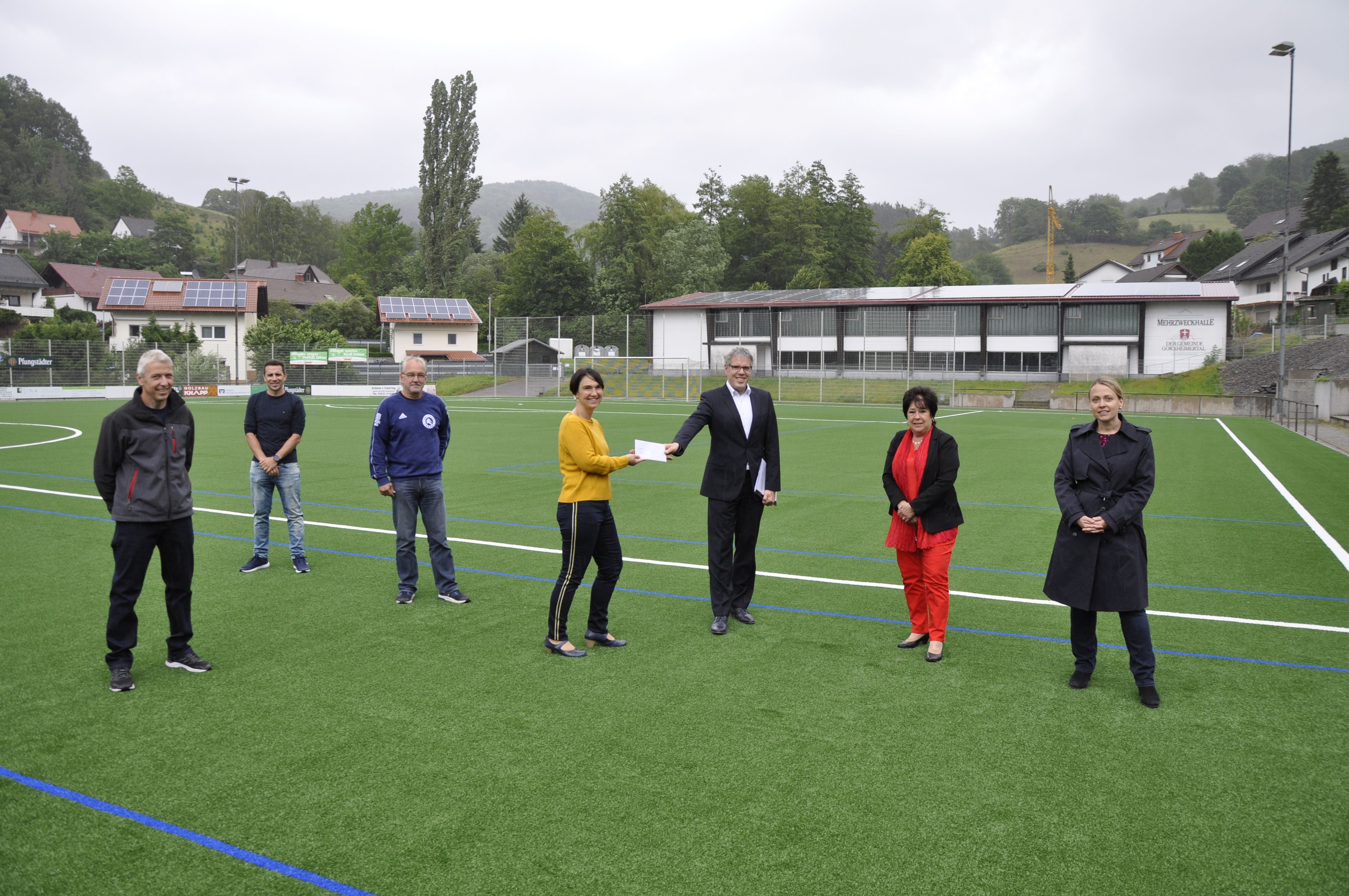Landrat Christian Engelhardt (3.v.r.) überreichte der Ersten Vorsitzenden der TG Jahn Trösel, Silvia Möller (Mitte), einen Förderbescheid des Kreises über 5.000 Euro für den neuen Kunstrasen. Mit dabei (v.r.): Dr. Cornelia Röger-Göpfert (Geschäftsführerin von Morton Extrusionstechnik), Landtagsabgeordnete Karin Hartmann, die TG-Trösel-Kassierer Peter Hecker und Patrick Schmitt sowie Projektleiter Jürgen Möller.