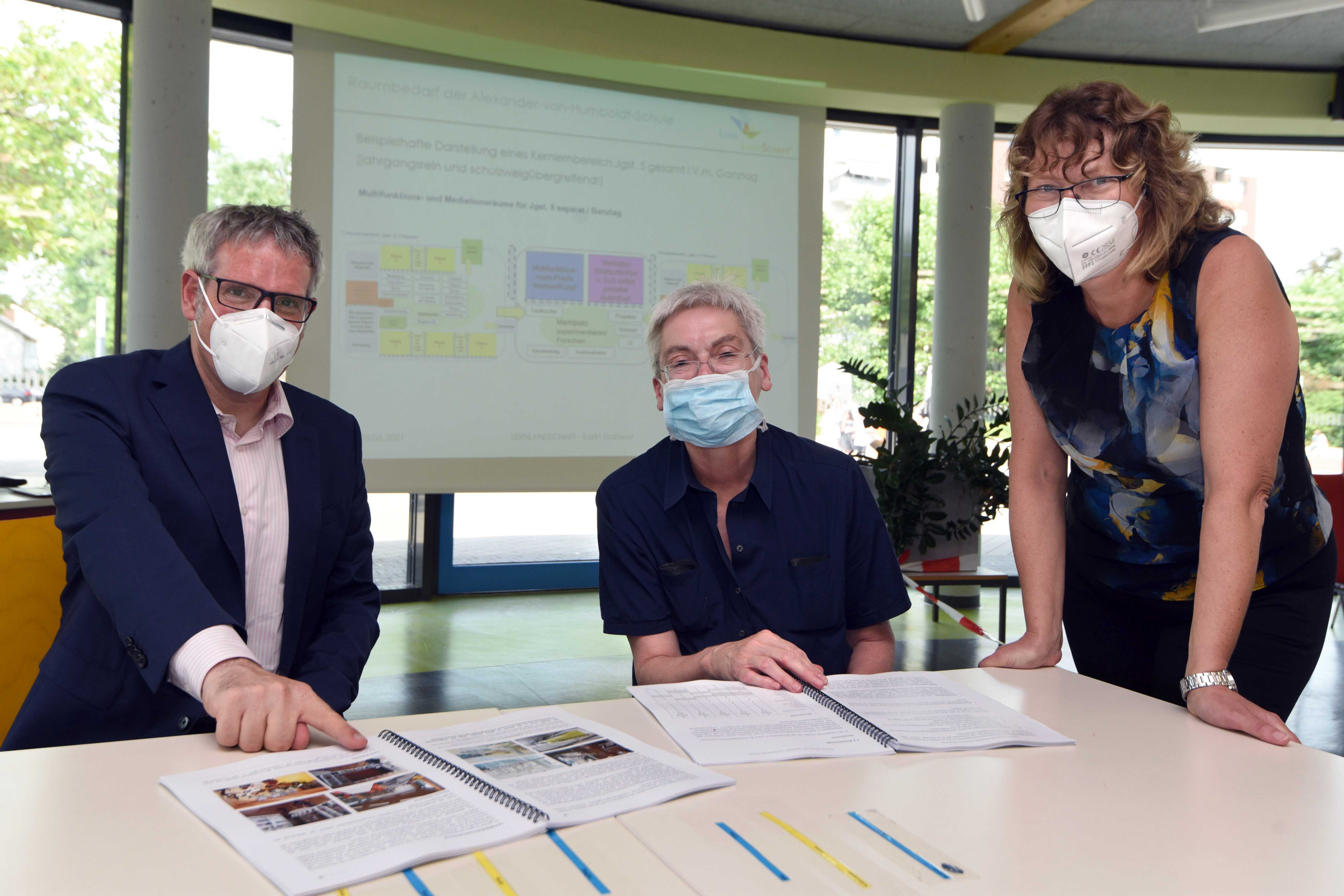 Landrat Christian Engelhardt (links), Karin Doberer (vom Planungsbüro LernLandSchaft, rechts) und Schulleiterin Cornelia Kohl beim Unterschreiben des Raumfunktionsbuches.