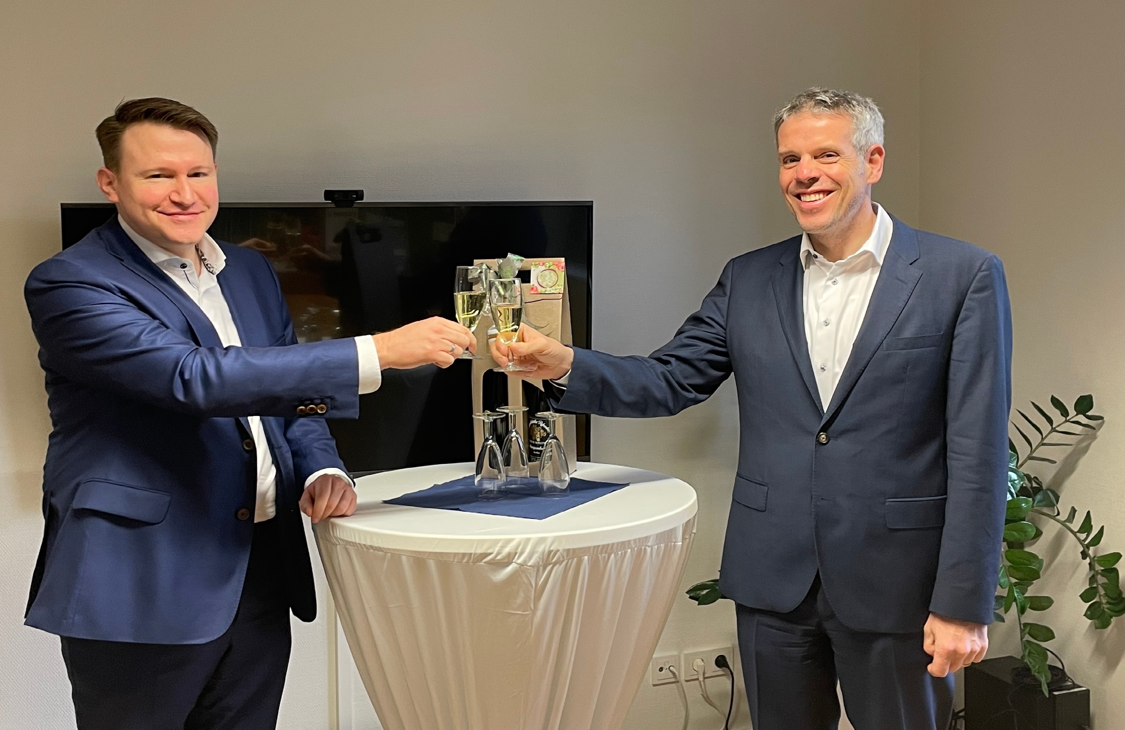 Dr. Matthias Zürker (links) und Landrat Christian Engelhardt stoßen auf das 10-jährige Dienstjubiläum von Herrn Dr. Zürker als Geschäftsführer der WFB an.