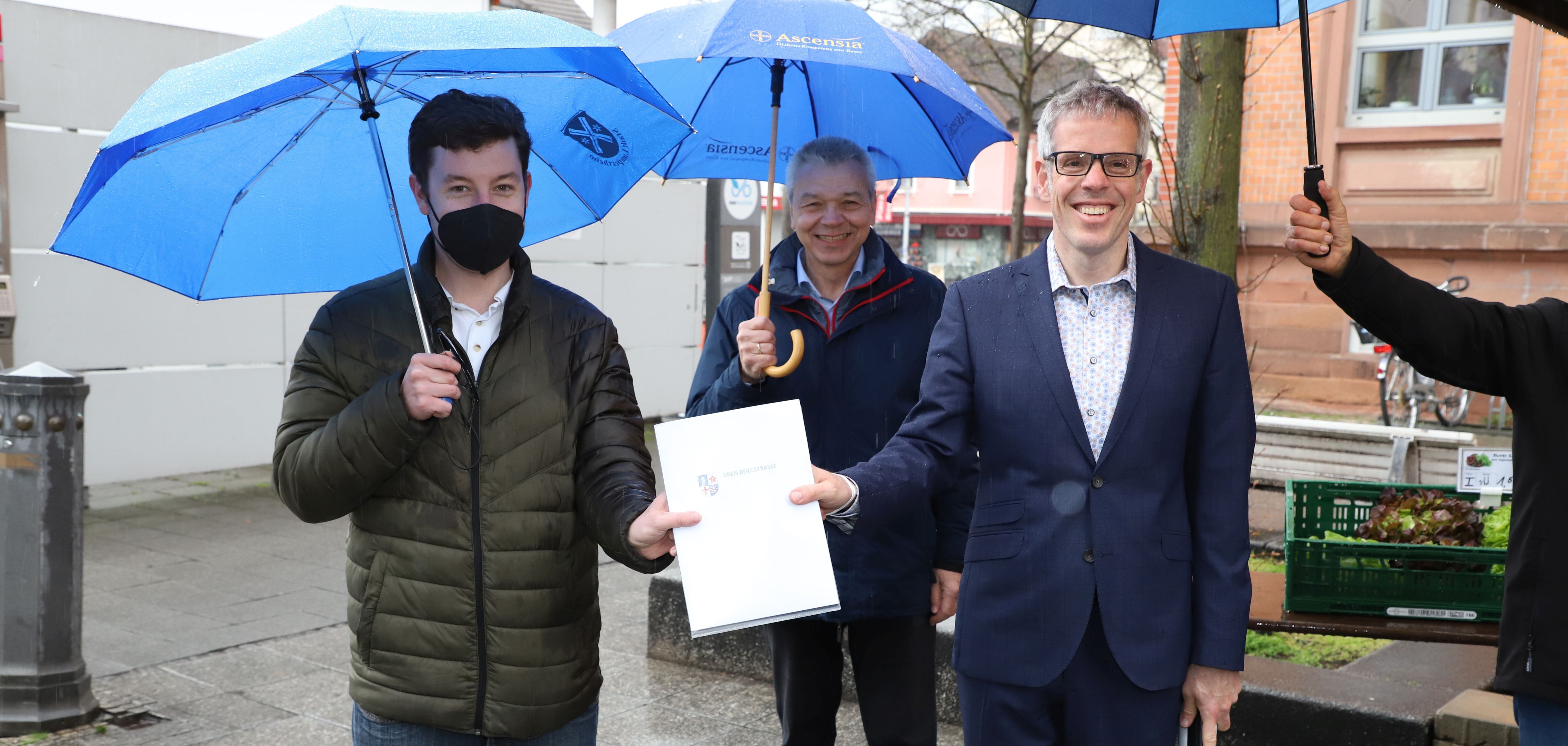 Landrat Christian Engelhardt (re.) übergibt den Förderbescheid für das Begegnungs- und Bildungszentrum an den Ersten Lampertheimer Stadtrat Marius Schmidt (li.), in der Mitte Lampertheims Bürgermeister Gottfried Störmer.