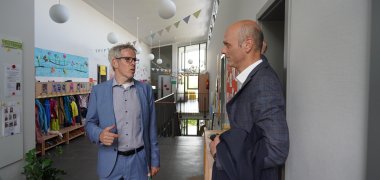 Landrat Christian Engelhardt und Bürgermeister Dr. Holger Habich stehen im Zwingenberger Kindergarten Alsbacher Straße im Flur und besprechen etwas.