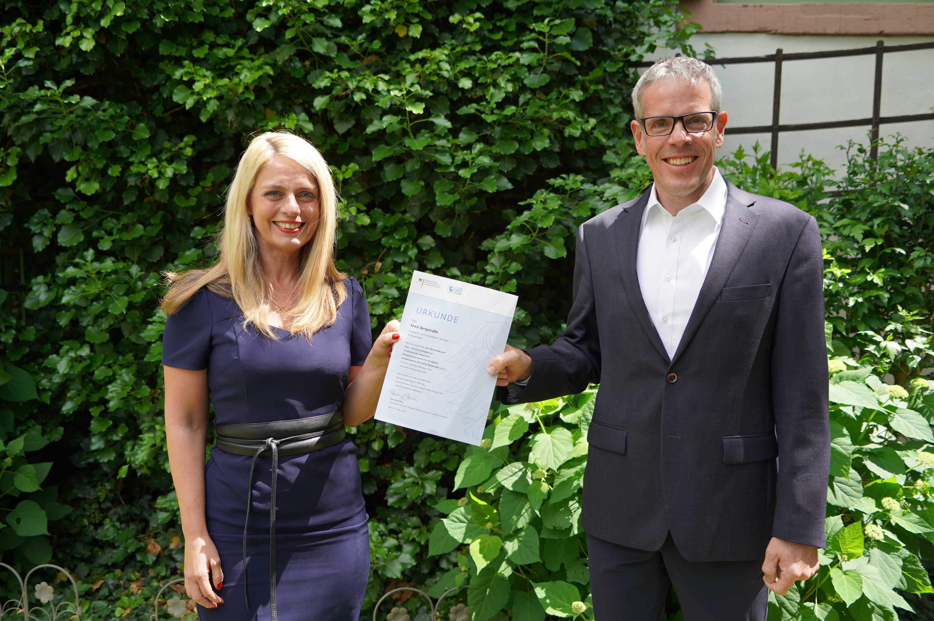 Landrat Christian Engelhardt und Corinna Simeth (Leiterin der Abteilung Kreisentwicklung und Grundsatz beim Kreis Bergstraße) mit dem Klimaschutz-Förderbescheid für den Kreis Bergstraße.