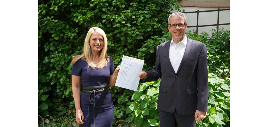 Landrat Christian Engelhardt und Corinna Simeth (Leiterin der Abteilung Kreisentwicklung und Grundsatz beim Kreis Bergstraße) mit dem Klimaschutz-Förderbescheid für den Kreis Bergstraße.