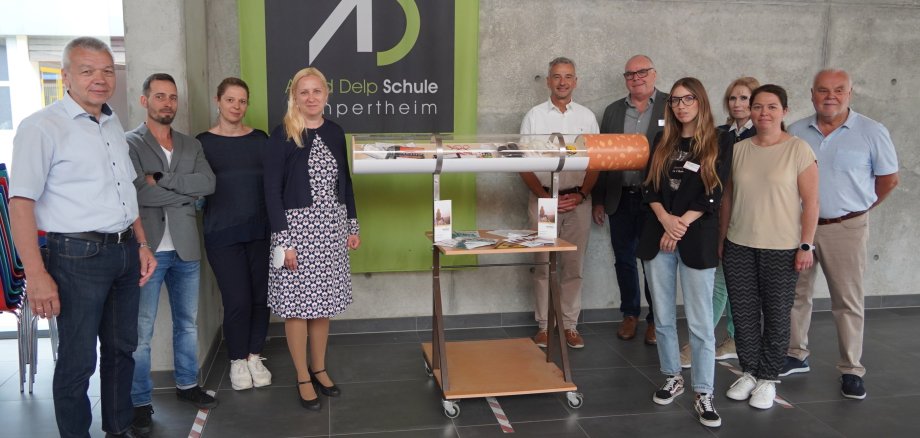 Das Bild zeigt ein Gruppenfoto von Menschen, die sich um eine große Modellzigarette versammeln. Das Modell  haben Schüler und Schülerinnen der Heinrich-Metzendorf-Schule in Bensheim gebaut. Auf dem Foto zu sehen sind Lampertheims Bürgermeister Gottfried Störmer, Ralf Stadler, Präventionslehrer an der Heinrich-Metzendorf-Schule in Bensheim, Sylvia Meier, Leiterin der Alfred-Delp-Schule in Lampertheim, die Erste Kreisbeigeordnete Diana Stolz, Dr. Karl-Wilhelm Klingler vom Lampertheimer Ärztenetzwerk Gala, Adrian Steier-Bertz, Fachbereichsleiter bei der AWO Prisma Suchthilfe & Prävention, Nikita Girard, Sozialpädagogin bei Prisma, Reinhild Zolg, Präventionsbeauftragte des Kreises Bergstraße, Petra Popp, stellvertretende Schulleiterin der Alfred-Delp-Schule und Andreas Förster von Gala. 