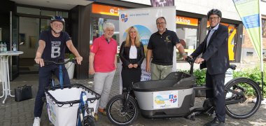 Landrat Christian Engelhardt, Tord Steinbock von Odenwaldbike Lorsch, Corinna Simeth (Leiterin der Abteilung Grundsatz und Kreisentwicklung beim Kreis Bergstraße), Wolfgang Bund vom Fahrradhaus Bensheim und Klimaschutzmanager Reiner Pfuhl (Kreis Bergstraße) stehen mit zwei Lastenrädern vor dem Geschäft von Odenwaldbike Lorsch.