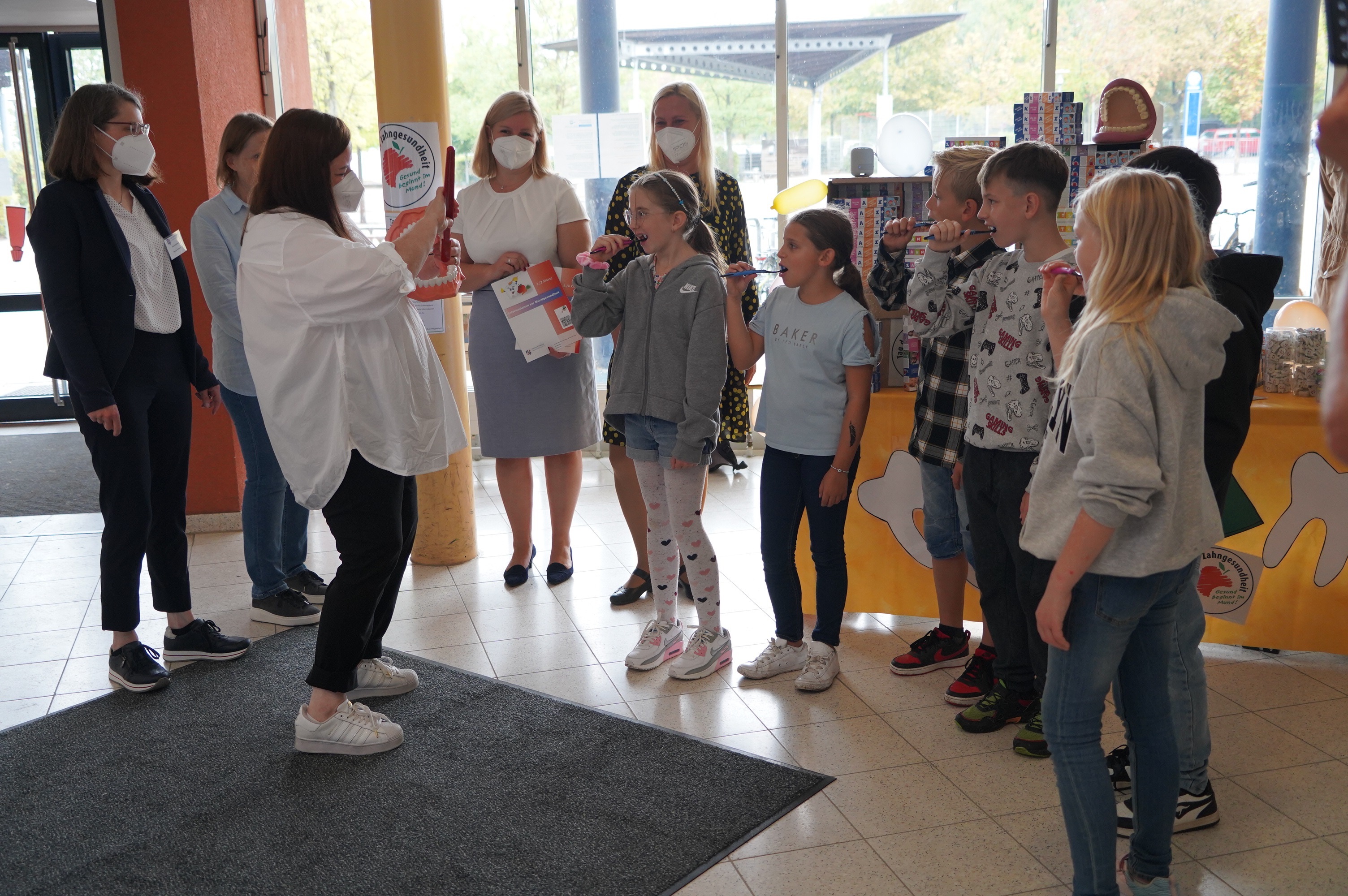 Beim Aktionstag an der Lampertheimer Pestalozzischule wurden die Zähne zu einem passenden Lied geputzt (v.l.n.r.): Heike Rohmann vom Zahnärztlichen Dienst des Bergsträßer Gesundheitsamts, Schulleiterin Michaela Ohse-Beck und Birgit Riefling (Zahnärztlicher Dienst) sowie Dr. Barbara Unger-Goldinger (Fachbereichsleitung Kinder- und Jugendärztlicher Dienst des Bergsträßer Gesundheitsamtes) und Gesundheitsdezernentin Diana Stolz mit Kindern der Schule. 