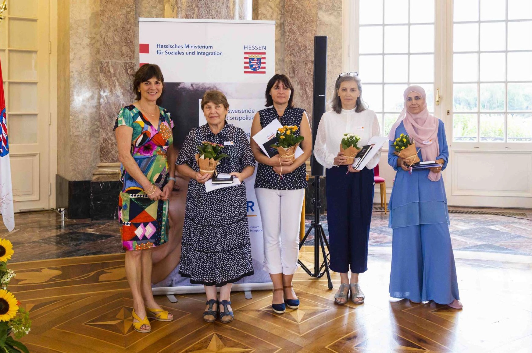 Beim Festakt in Wiesbaden: Staatssekretärin Anne Janz (l.), Tetyana Nareike (3. v. l.) und weitere Integrationslotsinnen im Schloss Biebrich. 