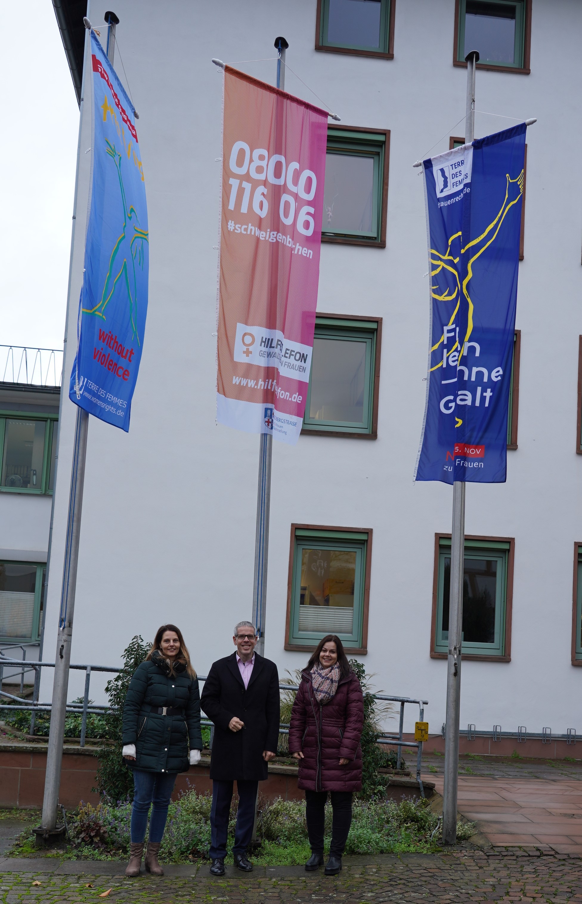 Sie zeigen Flagge gegen Gewalt an Frauen und Mädchen: Landrat Christian Engelhardt mit den Frauen- und Gleichstellungsbeauftragten des Kreises Bergstraße Nicole Schmitt (links) und Alexandra Schmitt.