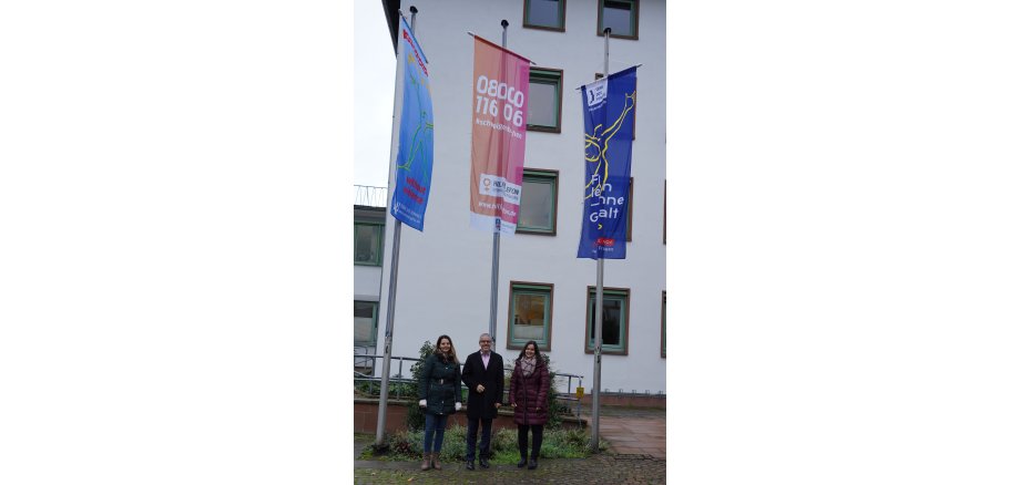 Sie zeigen Flagge gegen Gewalt an Frauen und Mädchen: Landrat Christian Engelhardt mit den Frauen- und Gleichstellungsbeauftragten des Kreises Bergstraße Nicole Schmitt (links) und Alexandra Schmitt.