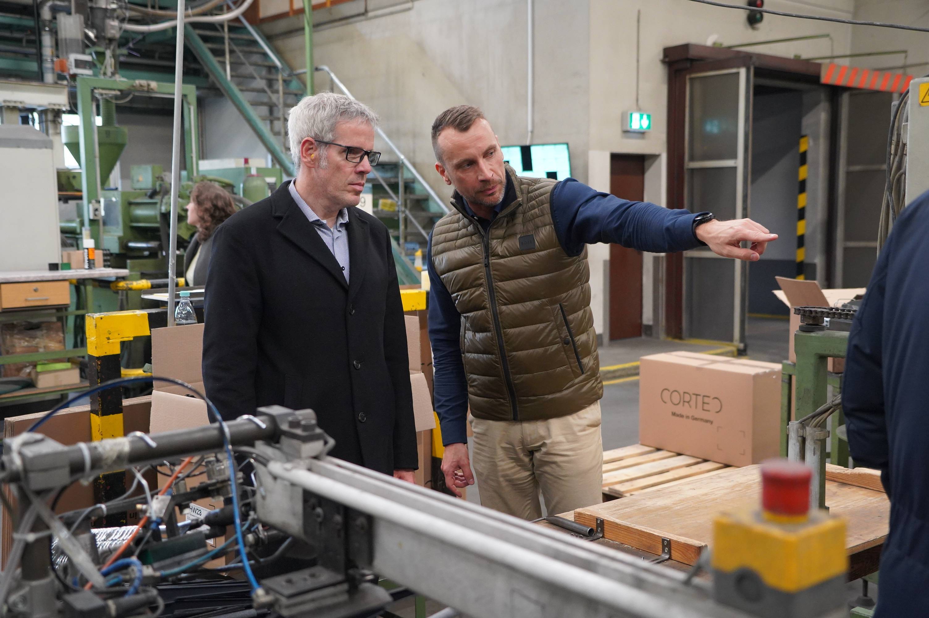 Nachhaltigkeitstour durch den Kreis Bergstraße Geschäftsführer Torsten Schmitt (links) zeigt Landrat Christian Engelhardt (rechts) wie die nachhaltigen Kleiderbügel in Wahlen produziert werden.