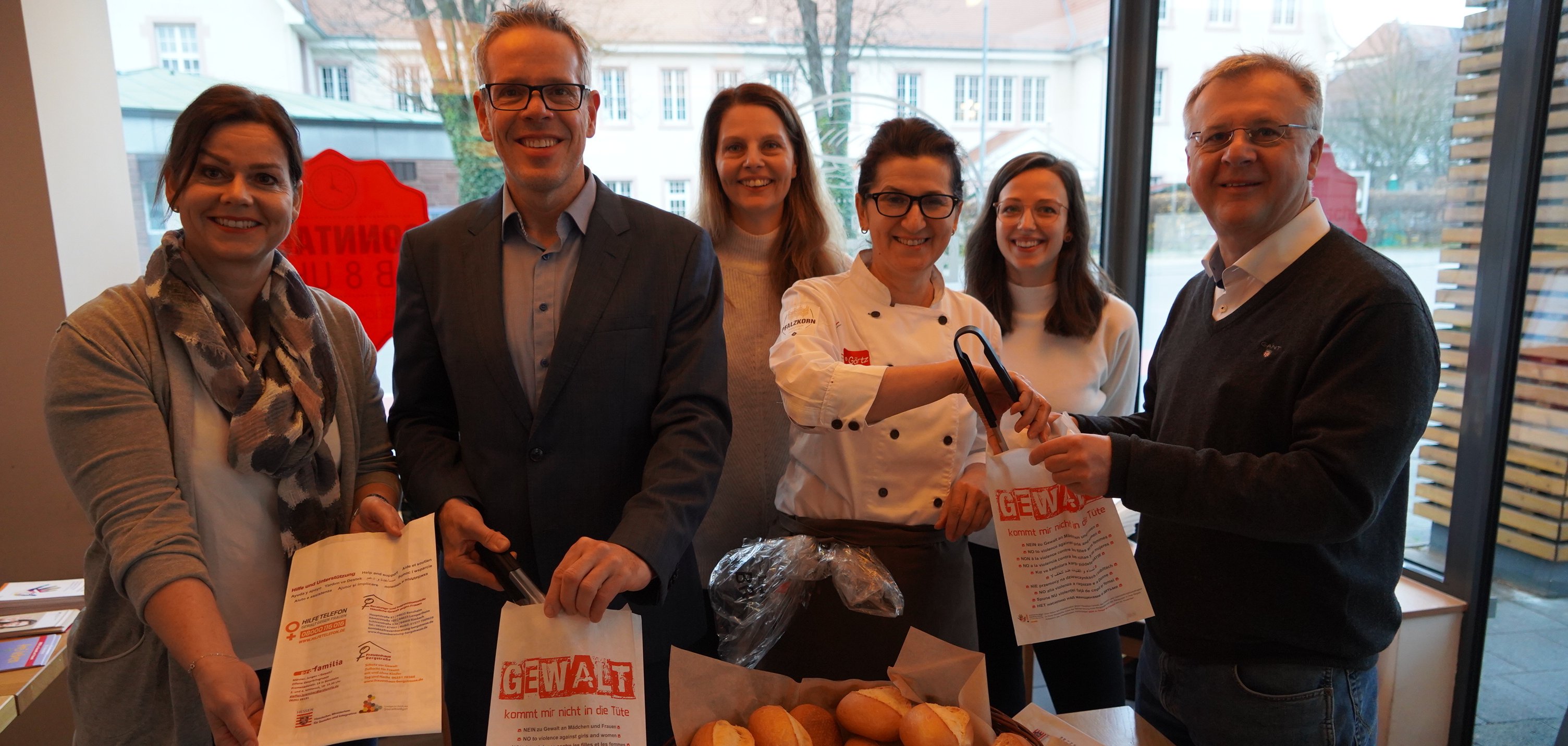 Da häusliche Gewalt jede Person, egal welcher gesellschaftlichen Schicht, sexueller oder politischer Orientierung oder Religionszugehörigkeit betreffen kann, ist es wichtig, das Thema einer breiten Öffentlichkeit nahe zu bringen. Zu diesem Zweck verteilten am vergangenen Samstag, 10. Dezember, Landrat Christian Engelhardt (2. v.l.) und Heppenheims Bürgermeister Rainer Burelbach (r.) bei der Bäckerei Görtz in der Ludwigstraße in Heppenheim Brötchentüten im Rahmen der Aktion „Gewalt kommt mir nicht in die Tüte“ an die Kundinnen und Kunden. 