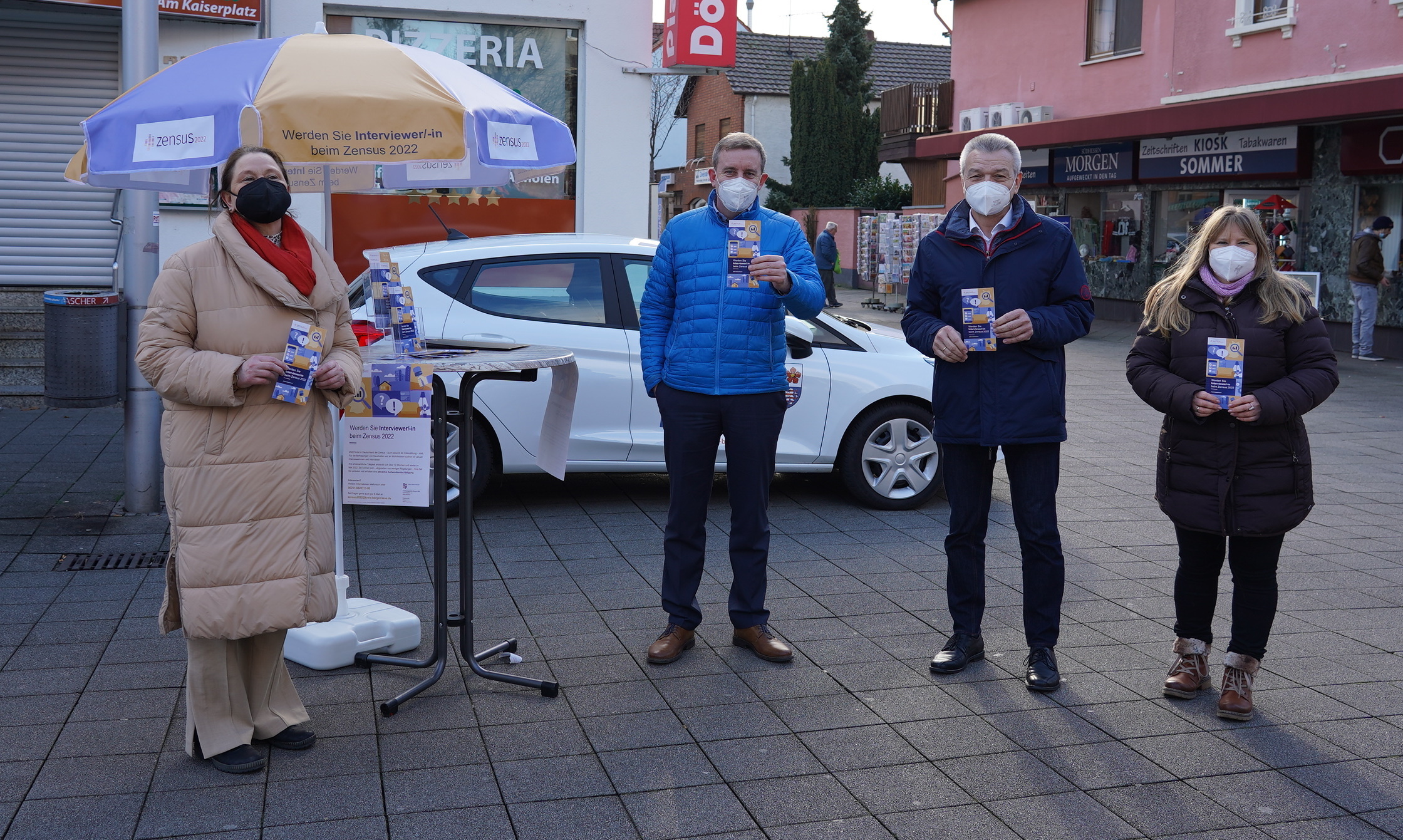 Das Team des Zensus 2022 freut sich, ausgestattet mit Infomaterial, auf Ihren Besuch! Beim Stopp auf dem Lampertheimer Wochenmarkt wurde das Promo-Team Kirsten Rausch (links außen) und Kirstin Neeb (rechts außen) vom hauptamtlichen Kreisbeigeordneten Karsten Krug (Mitte links) und dem Lampertheimer Bürgermeister Gottfried Störmer (Mitte rechts) unterstützt.