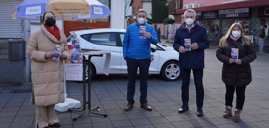 Das Team des Zensus 2022 freut sich, ausgestattet mit Infomaterial, auf Ihren Besuch! Beim Stopp auf dem Lampertheimer Wochenmarkt wurde das Promo-Team Kirsten Rausch (links außen) und Kirstin Neeb (rechts außen) vom hauptamtlichen Kreisbeigeordneten Karsten Krug (Mitte links) und dem Lampertheimer Bürgermeister Gottfried Störmer (Mitte rechts) unterstützt.