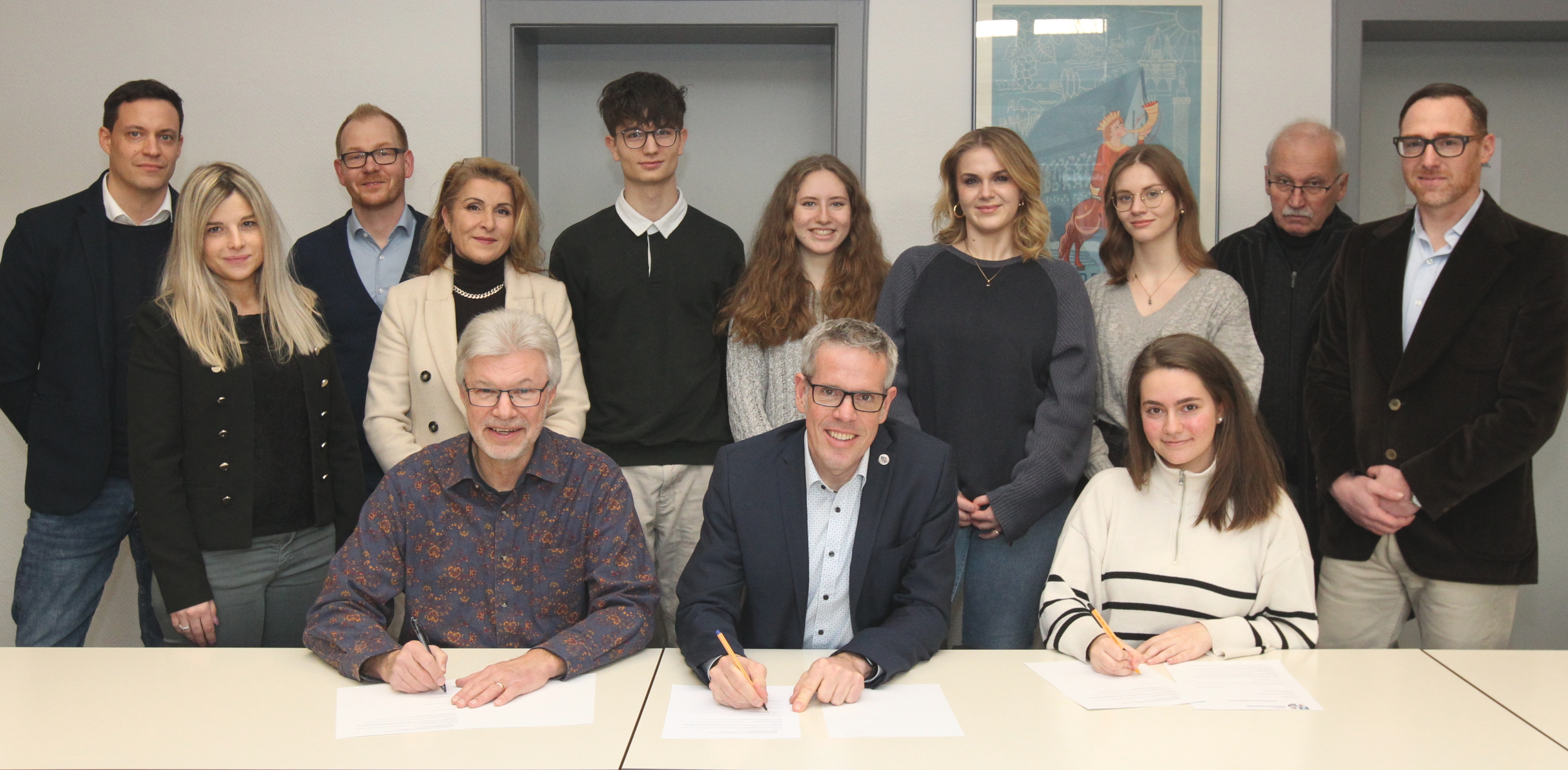 Landrat Christian Engelhardt (Mitte), der Vorsitzende der Kreiselternvertretung Thomas Sohler (links) und die Vorsitzende der Kreisschülervertretung Aylin Erdogan (rechts) besiegeln ihr gemeinsames Vorhaben mit der Unterzeichnung einer gemeinsamen Kooperationsvereinbarung für den Medienbildungstag.