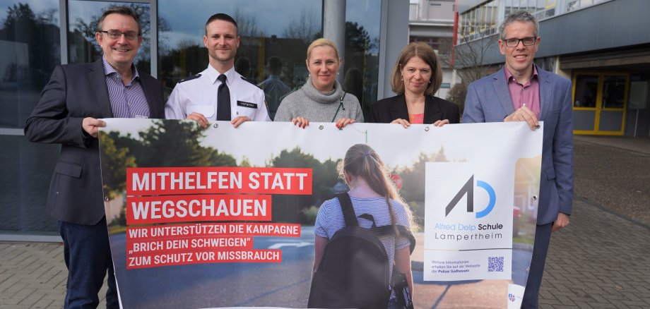 Gemeinsam gegen sexuellen Missbrauch: Landrat Christian Engelhardt, die Leiterin der Alfred-Delp-Schule Sylvia Meier, die Erste Kreisbeigeordnete Diana Stolz, der Jugendkoordinator der Polizeidirektion Bergstraße Johannes Emanuel Hofmann und Kriminalhauptkommissar Michael Rühl (v.r.n.l.) mit dem Banner der Kampagne „Brich Dein Schwiegen – hinter jedem Missbrauch steckt ein Gesicht“.