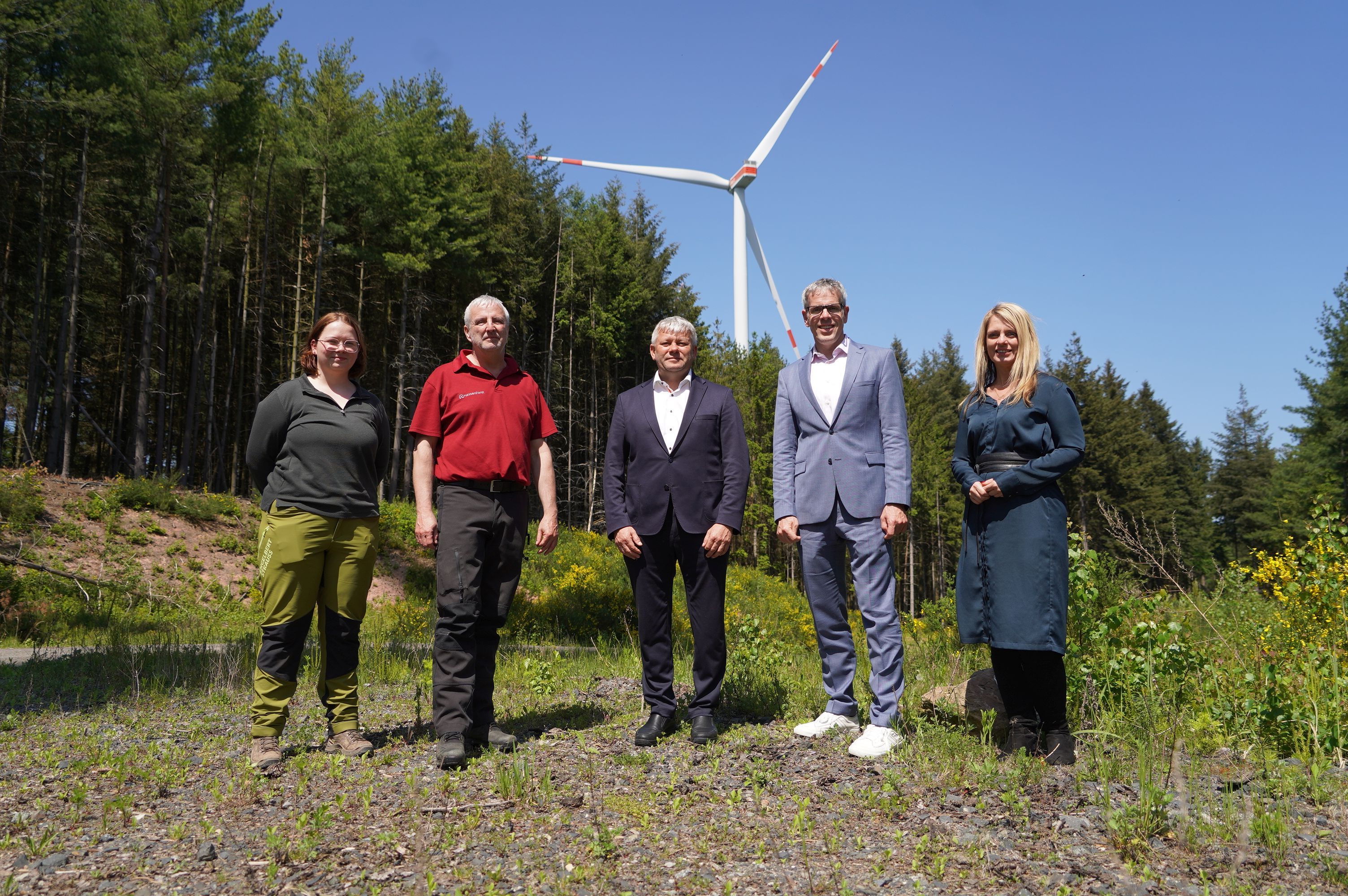 Landrat Christian Engelhardt (2.v.r.) und Corinna Simeth (rechts) vom Kreis Bergstraße informierten sich bei (v.r.n.l.) Bürgermeister Volker Oehlenschläger sowie Jürgen Heumüller und Anabel Heß vom Forstamt Lampertheim über den Windpark Kahlberg zwischen Fürth und Grasellenbach. Auf dem Bild stehen sie im Wald vor einem der Windräder.