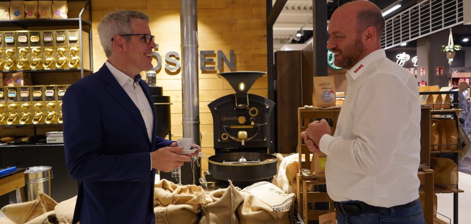 Landrat Christian Engelhardt (links) und Daniel Ludorf (rechts) testen auf dem Bild den selbst vor Ort gerösteten Kaffee.