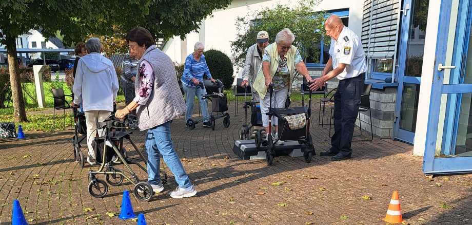 Der Polizeihauptkommissar der Polizei Südhessen Ralf Drexelius (re.) gab den Teilnehmerinnen und Teilnehmern des von der PauLa des Kreises Bergstraße organisierten Rollator-Trainings wichtige Tipps im Umgang mit den Gehhilfen.  