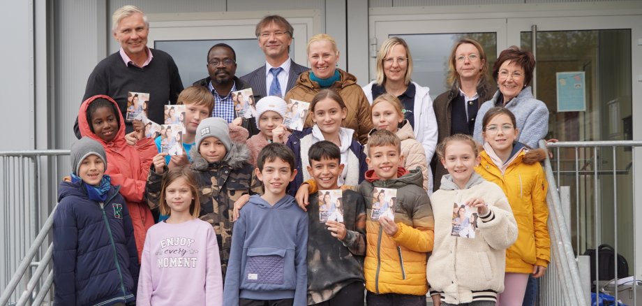 Die Erste Kreisbeigeordnete und Gesundheitsdezernentin Diana Stolz, die Bürstädter Bürgermeisterin Barbara Schader, der Präsident des Vereins Gesundheitsnetz Rhein-Neckar e.V., Dr. Claus Köster, Dr. Nobila Ouédraogo vom Deutschen Krebsforschungszentrum, Schulleiter Torsten Wiechmann, die Fachärztin für Kinder- und Jugendmedizin, Dr. Daniela Klee, und die Fachärztin für Gynäkologie und Geburtshilfe, Dr. Inka Scheer, mit einigen Schülerinnen und Schülern der 4. Klasse beim HPV-Impfaktionstag an der Schillerschule Bürstadt.