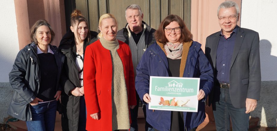 Die Erste Kreisbeigeordnete und Gesundheitsdezernentin Diana Stolz, die beiden PauLas für die Gemeinden im Ried (NORIE), Christina Adler-Schäfer und Michaela Weber, die Leiterin des Familienzentrums Lampertheim, Sabrina Mohr, der Übungsleiter vom Lampertheimer Lauftreff e.V., Jürgen Massonne sowie der Lampertheimer Bürgermeister Gottfried Störmer stehen vor dem Eingang des Lampertheimer Rathauses.