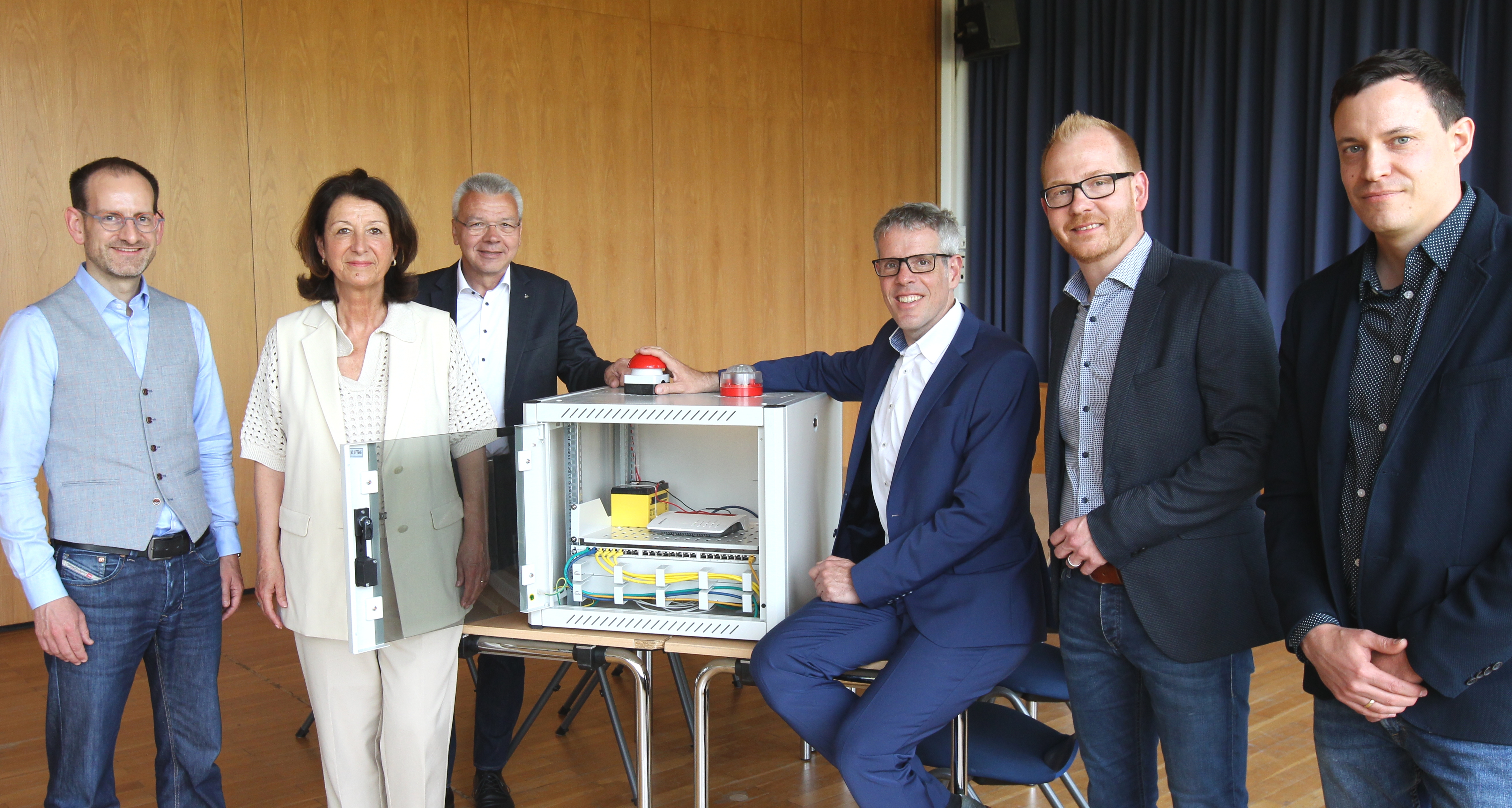 Christian Kaiser (Techniker, Eigenbetrieb Schule und Gebäudewirtschaft des Kreises), Johannes Kühn (Technischer Betriebsleiter, Eigenbetrieb), Nicole Träger (Konrektorin, Schillerschule Viernheim), Lisa Galvagno (Vorsitzende des Ausschusses Schule und Soziales, Kreis Bergstraße), Simon Menden (Kaufmännischer Betriebsleiter, Eigenbetrieb) und Ute Molden (Stabstelle Bildung und Pädagogik, Kreis Bergstraße) stehen bei einem Buzzer zum Breitband-Start.