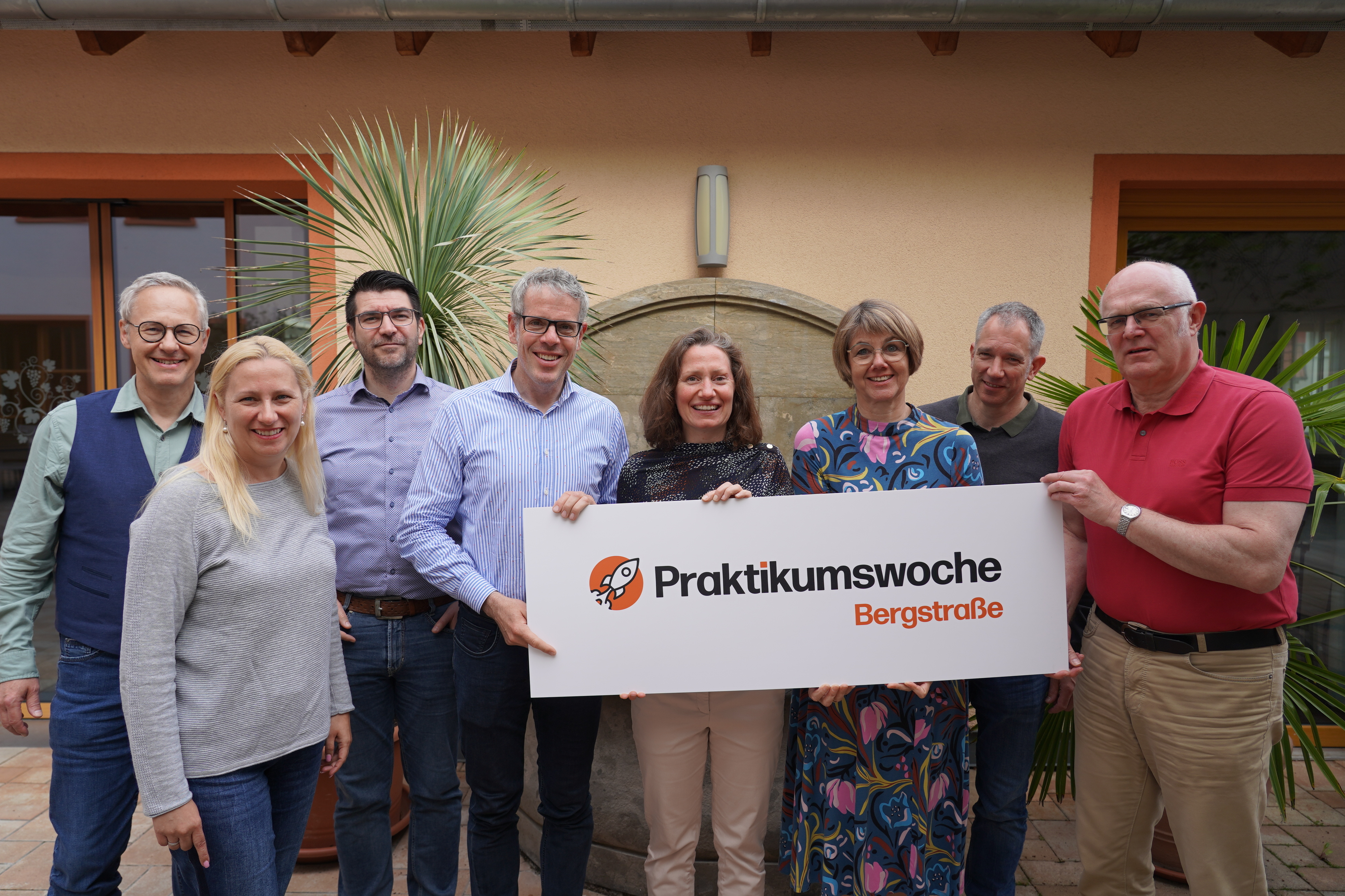 Der Landrat Christian Engelhardt und die Erste Kreisbeigeordnete Diana Stolz halten gemeinsam mit einigen Mitarbeiterinnen und Mitarbeitern der Kreisverwaltung das Schild zur Ankündigung der Praktikumswoche Bergstraße.