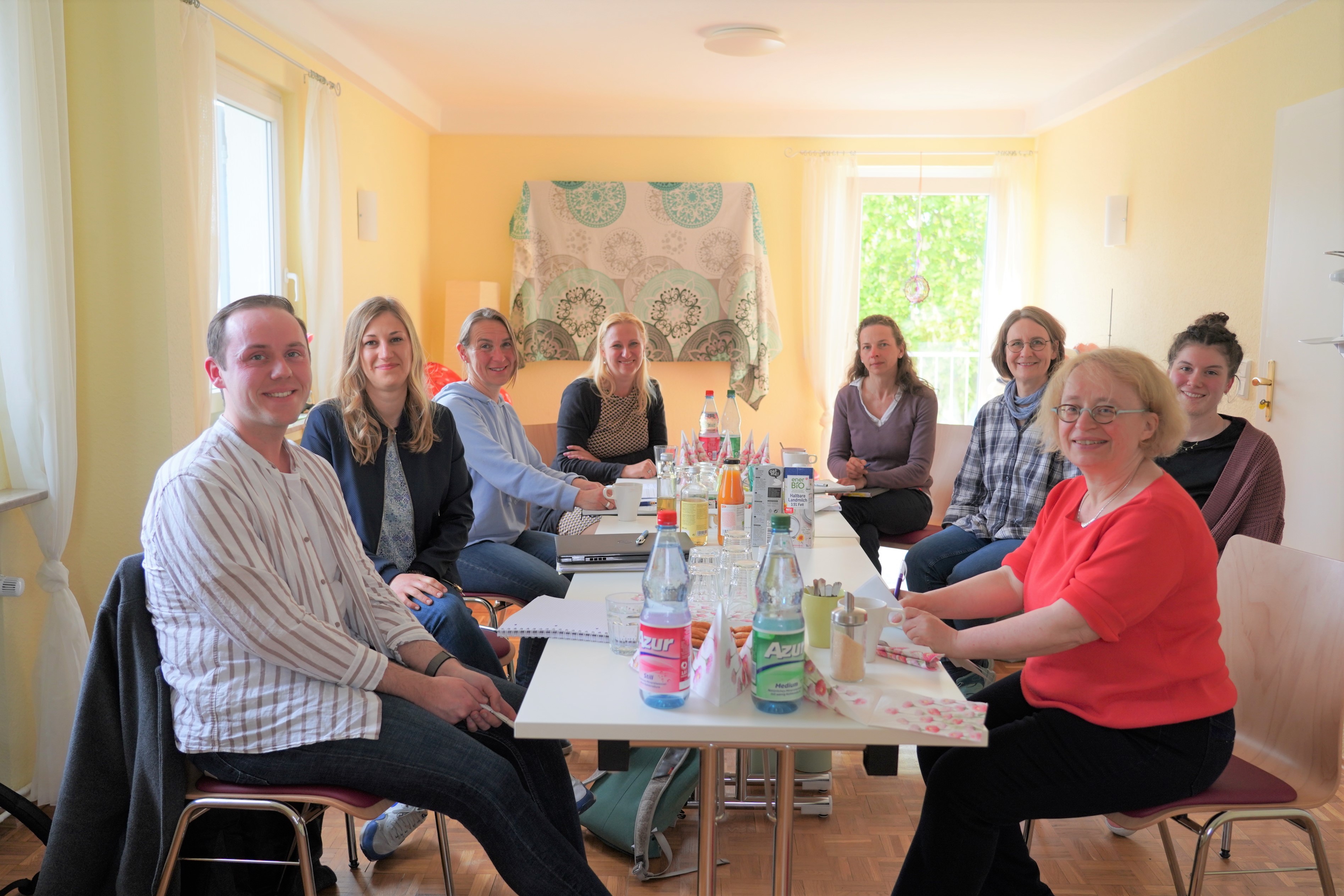Die Teilnehmerinnen und Teilnehmer des Hebammennetzwerkes sitzen im Geburtshaus an einem Tisch.