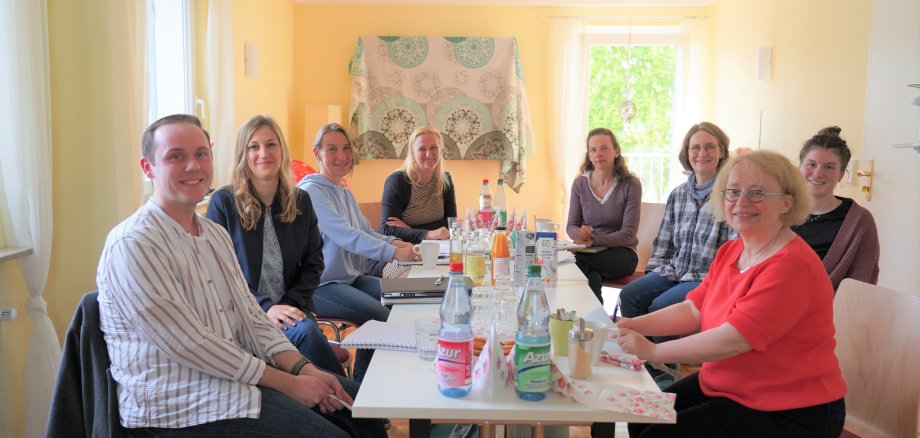 Die Teilnehmerinnen und Teilnehmer des Hebammennetzwerkes sitzen im Geburtshaus an einem Tisch.