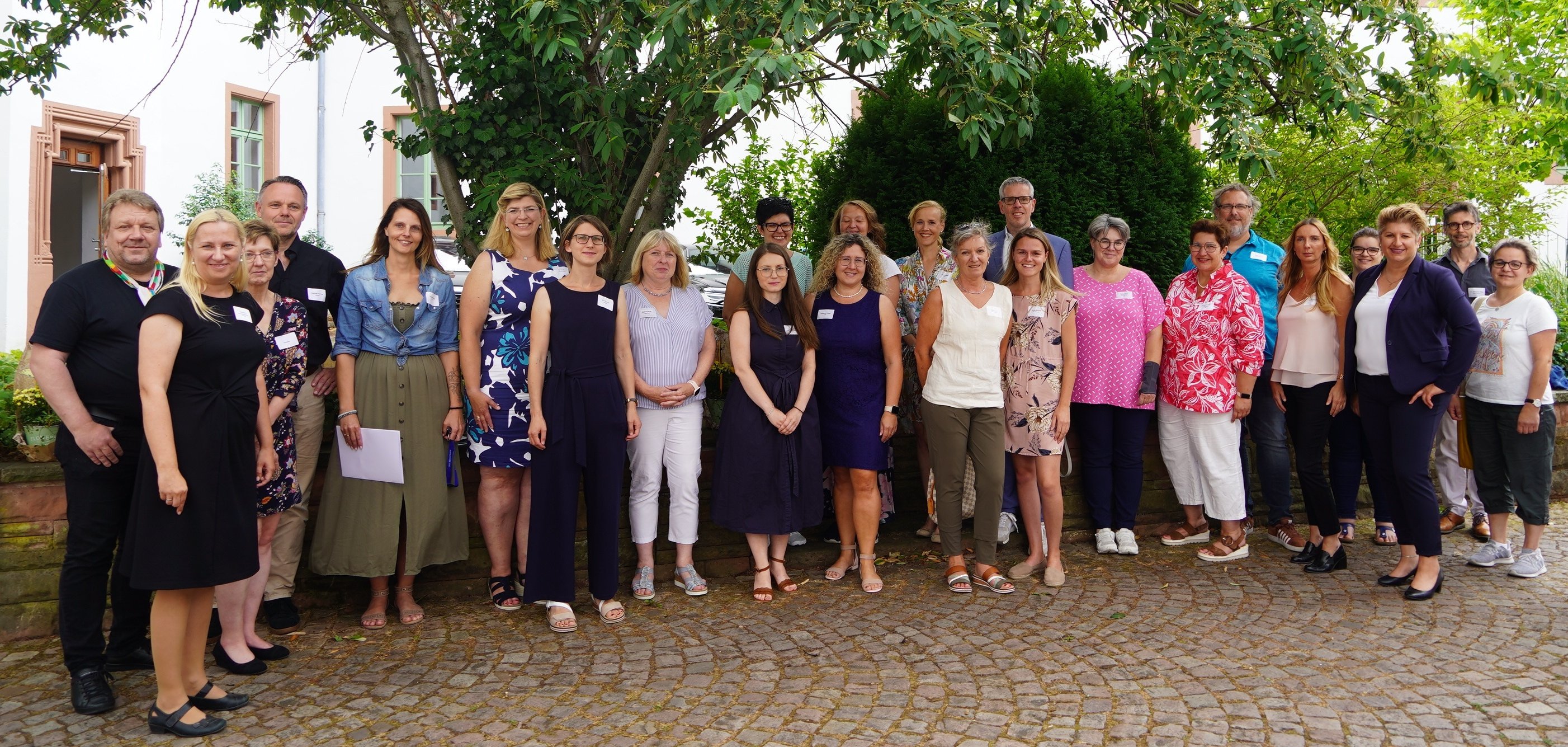 Landrat Christian Engelhardt und die Mitarbeiterinnen und Mitarbeiter der Kreisverwaltung stehen im Innenhof des Landratsamtes vor einem Baum.