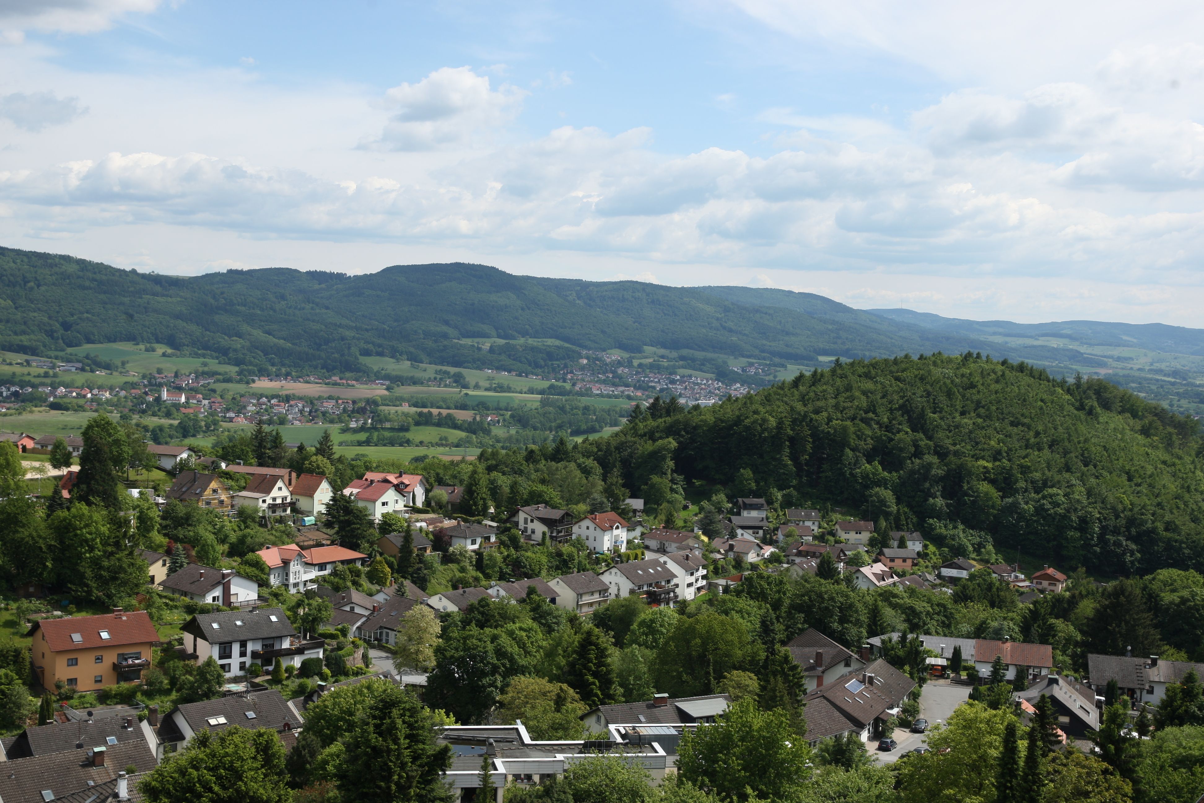 Eine Luftaufnahme, die Lindenfels und im Hintergrund den Odenwald zeigt.