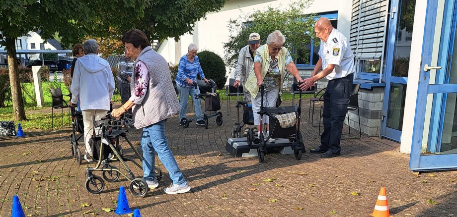 Der Vorsitzende der Kreisverkehrswacht Odenwald und Polizeihauptkommissar der Polizei Südhessen Ralf Drexelius (re.) – hier bei einem entsprechenden Kurs in Rimbach – gibt den Teilnehmerinnen und Teilnehmern des von den PauLas des Kreises Bergstraße organisierten Rollator-Trainings Tipps im Umgang mit den Gehhilfen.