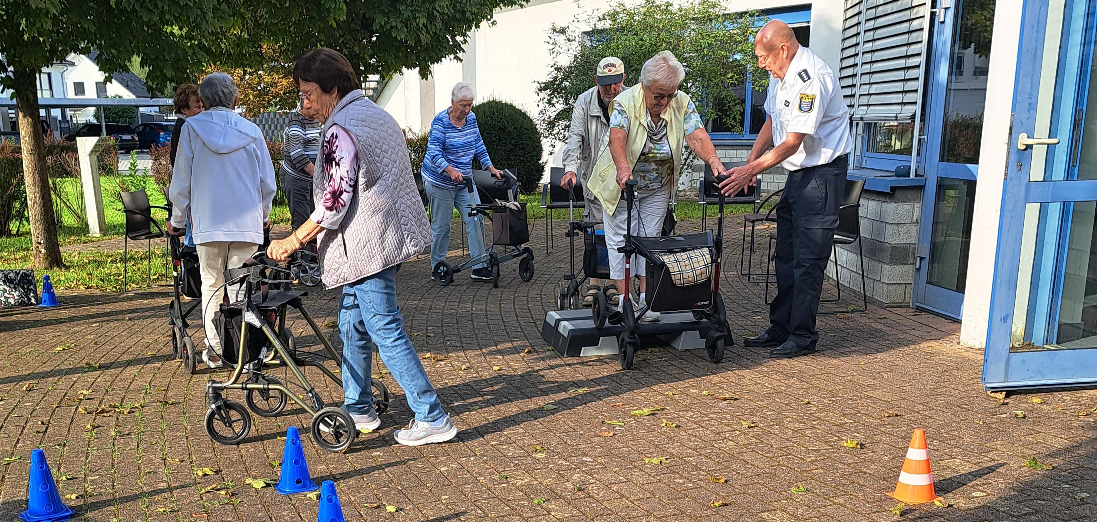 Der Vorsitzende der Kreisverkehrswacht Odenwald und Polizeihauptkommissar der Polizei Südhessen Ralf Drexelius (re.) – hier bei einem entsprechenden Kurs in Rimbach – gibt den Teilnehmerinnen und Teilnehmern des von den PauLas des Kreises Bergstraße organisierten Rollator-Trainings Tipps im Umgang mit den Gehhilfen.