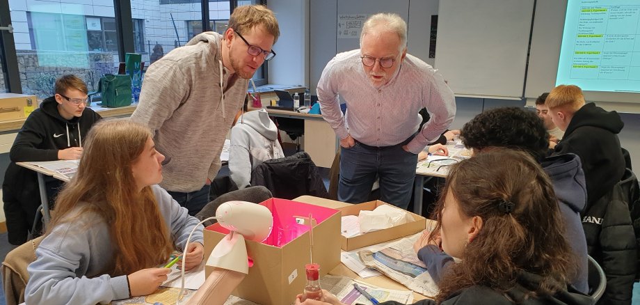 Schülerinnen und Schüler der Realschulklasse 10d der Geschwister-Scholl-Schule in Bensheim stellen den Klimaschutzmanagern des Kreises Bergstraße, Reiner Pfuhl und Alexander Uhl, ihre Klimaexperimente vor.