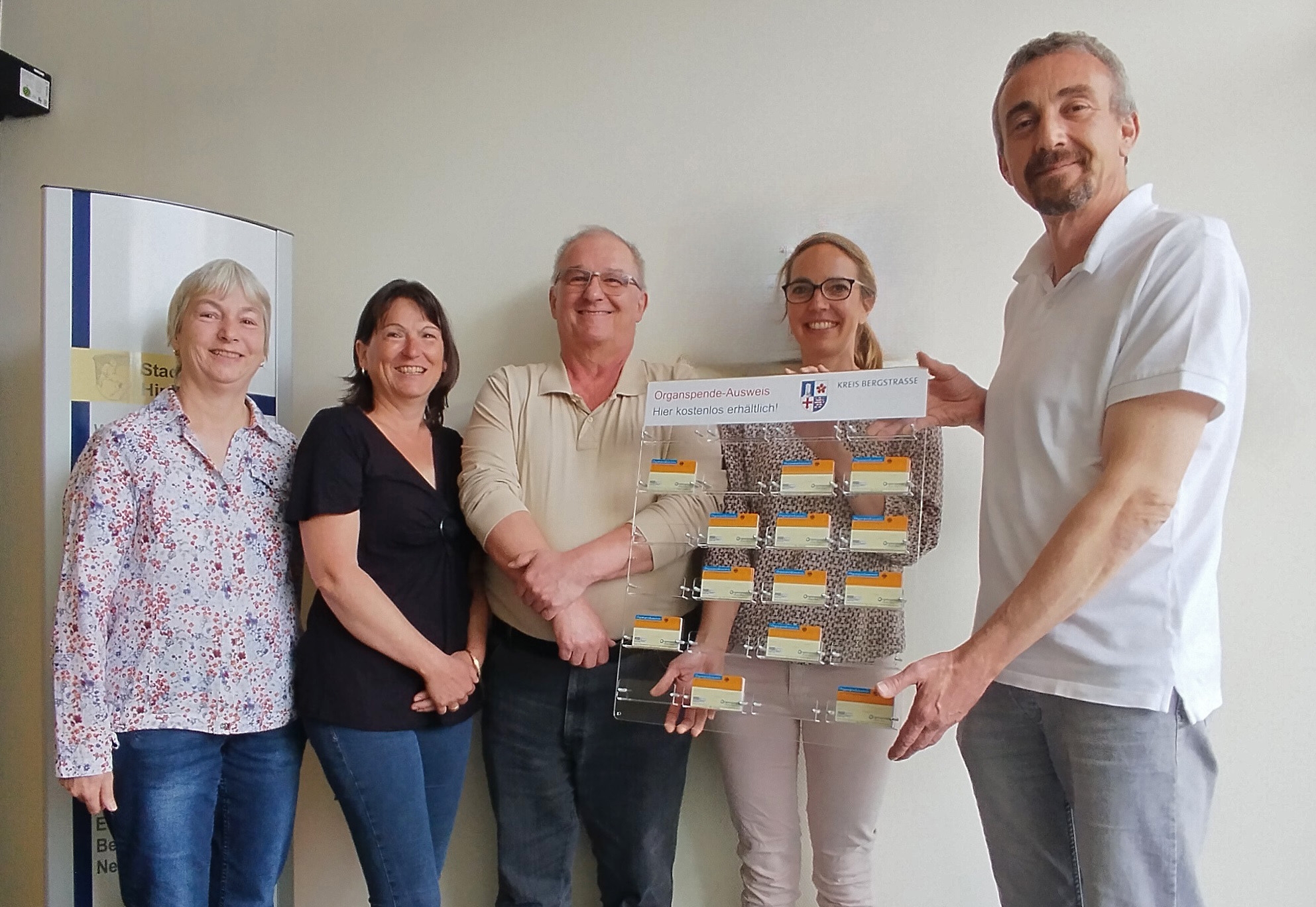 Der Bürgermeister der Stadt Hirschhorn, Martin Hölz, hält gemeinsam mit der Fachärztin für Allgemeinmedizin, Dr. Stefanie Soder, dem Stammzellen-Empfänger Peter Hofmann, seiner Schwester und Stammzellen-Spenderin Inge König sowie seiner Ehefrau, Ursula Hofmann die achte Organspende-Ausweistafel im Kreisgebiet in den Händen.