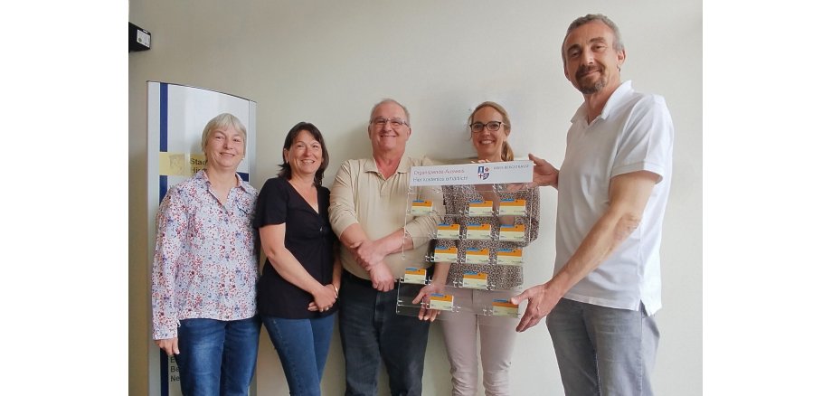 Der Bürgermeister der Stadt Hirschhorn, Martin Hölz, hält gemeinsam mit der Fachärztin für Allgemeinmedizin, Dr. Stefanie Soder, dem Stammzellen-Empfänger Peter Hofmann, seiner Schwester und Stammzellen-Spenderin Inge König sowie seiner Ehefrau, Ursula Hofmann die achte Organspende-Ausweistafel im Kreisgebiet in den Händen.