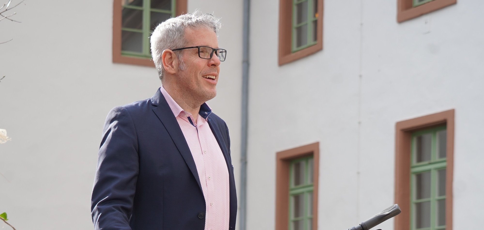 Landrat Christian Engelhardt wird die Fahrradmesse am 12. Juni im Innenhof des Heppenheimer Landratsamtes eröffnen. Auf dem Bild steht er mit einem schwarzen Fahrrad auf dem Innenhof des Landratsamtes.