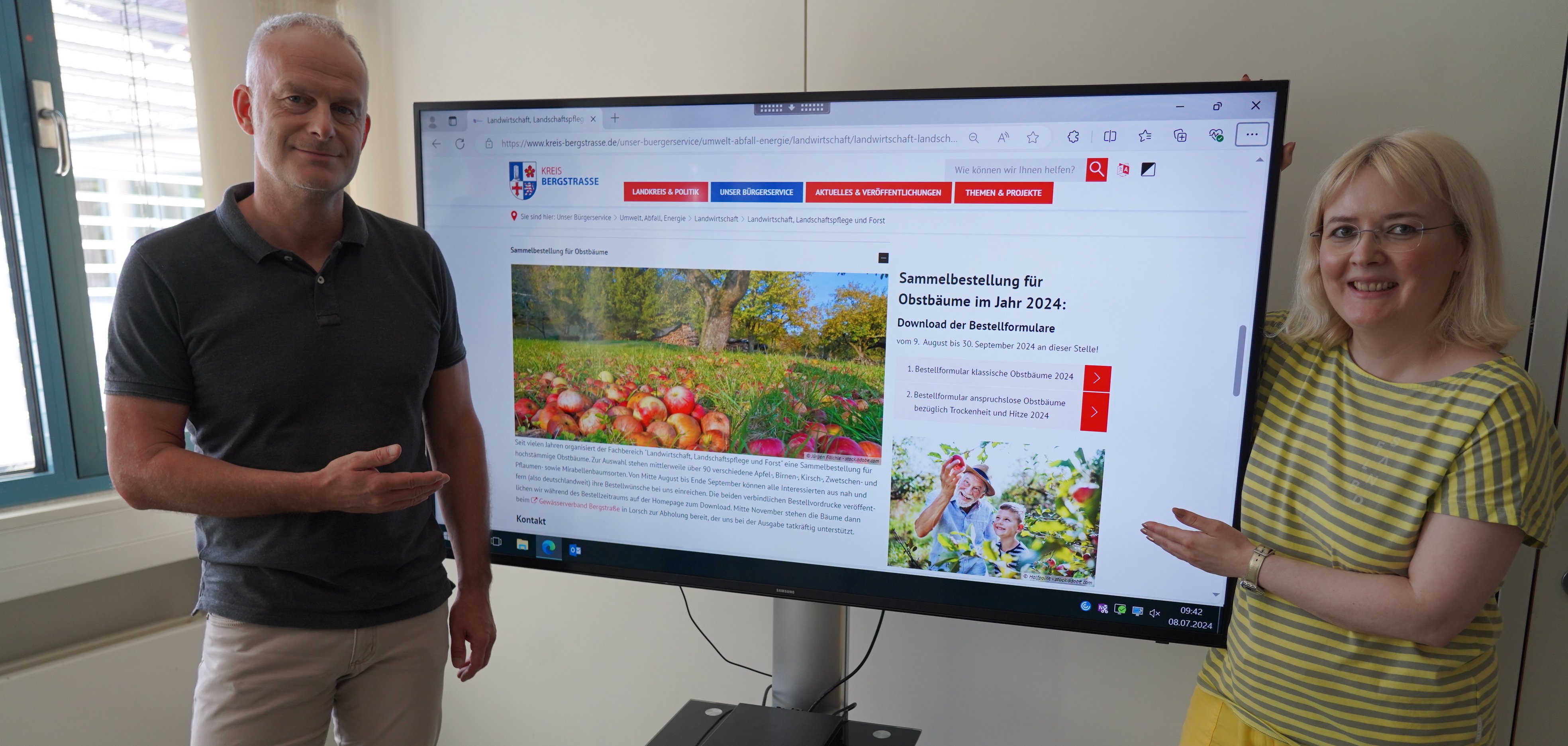 Der Leiter der Abteilung Ländlicher Raum, Thomas Renkert und seine Mitarbeiterin Ute Schollmaier zeigen auf einen Bildschirm, auf dem die Obstbaumbestellungen auf der Homepage des Kreises aufgerufen ist.