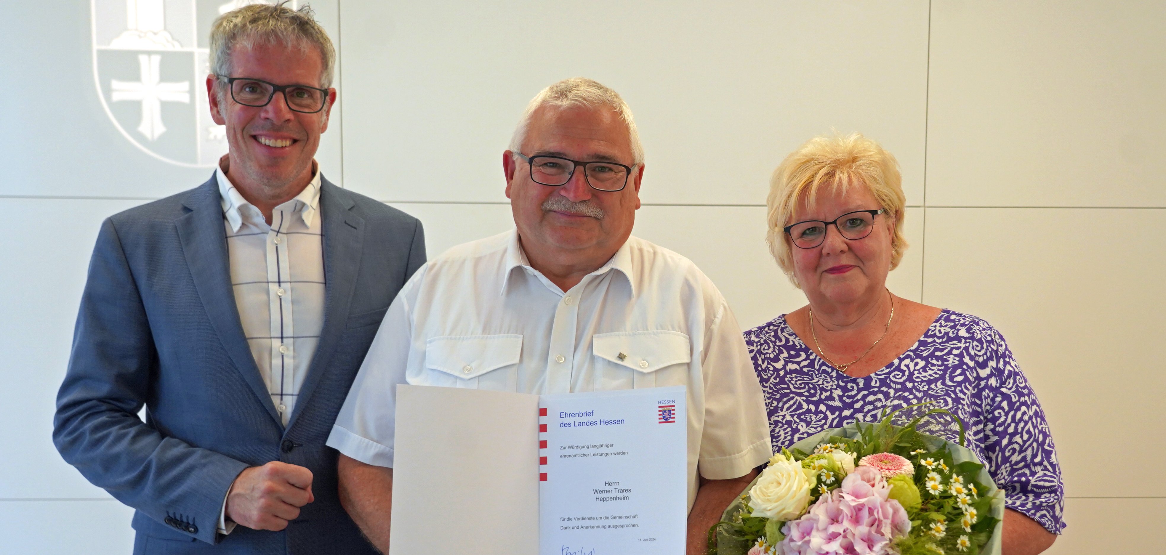 Landrat Christian Engelhardt (li.) verabschiedete Kreisbrandmeister und stellvertretenden Kreisbrandinspektor Werner Trares (Mitte), hier mit seiner Frau Christiane, nicht nur in den Ruhestand, er überreichte ihm auch den hessischen Landesehrenbrief.