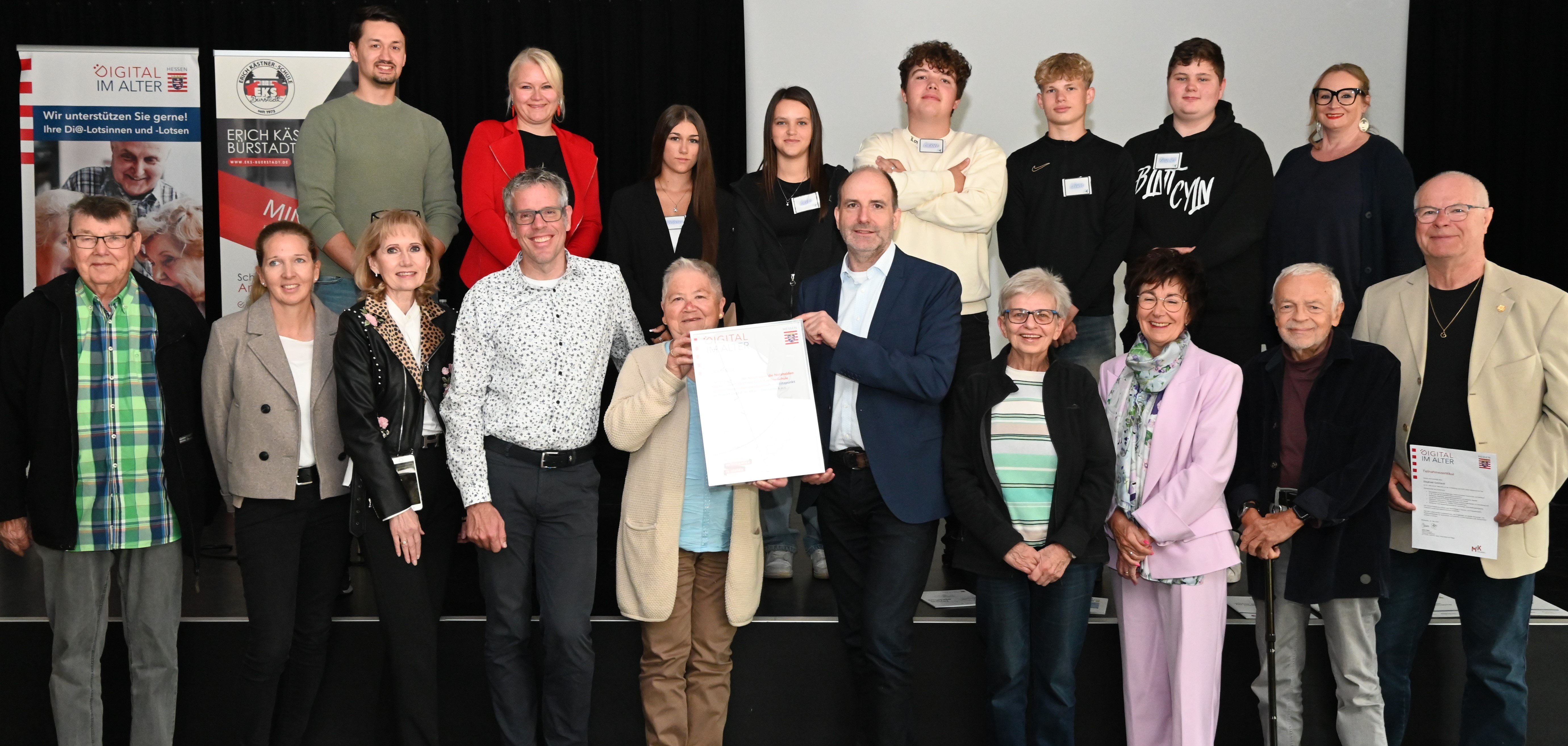 Bei der feierlichen Einweihung des neuen Di@-Lotsen Stützpunktes überreicht Landrat Christian gemeinsam mit der ersten Vorsitzenden des Seniorenbeirates Bürstadt, Annerose Bechtloff, Martin Gehl von der Landesstiftung „Miteinander in Hessen“ und der Bürgermeisterin der Stadt Bürstadt, Barbara Schader den anwesenden Digitallotsinnen und -lotsen, Lehrkräften sowie der Schulleiterin Stephanie Decker die offizielle Urkunde.