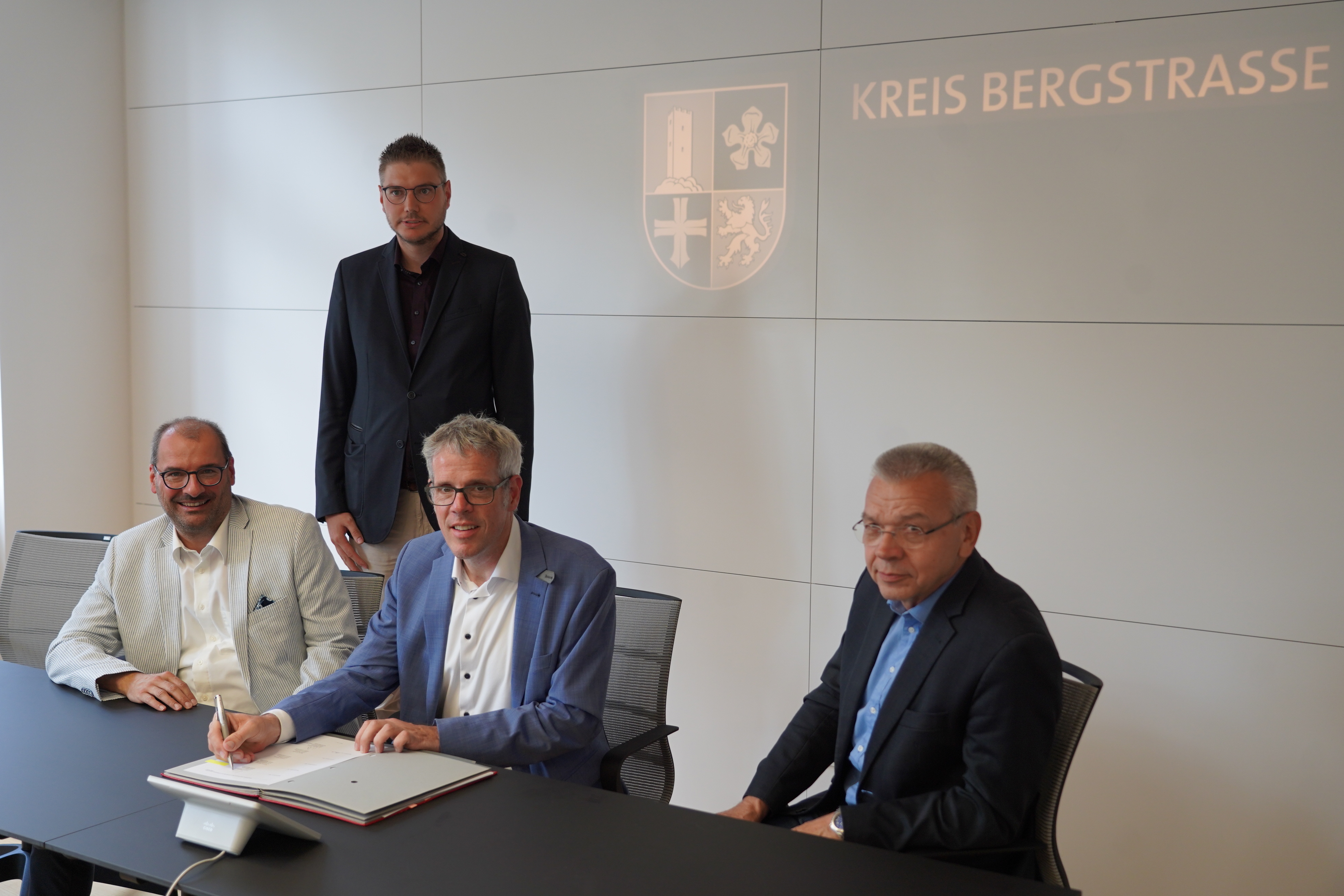 Landrat Christian Engelhardt (vorne, Mitte) unterzeichnete gemeinsam mit Dr. Michael Winnes (Geschäftsführer VRN, links) und Lampertheims Bürgermeister Gottfried Störmer (rechts) die Kooperations- und Finanzierungsvereinbarung zur Rückübertragung des ÖPNV-Linienbündels Lampertheim. Mit dabei: Dominik Perleth (Leiter der Abteilung Öffentlicher Personennahverkehr und Mobilität in der Kreisverwaltung, hinten).