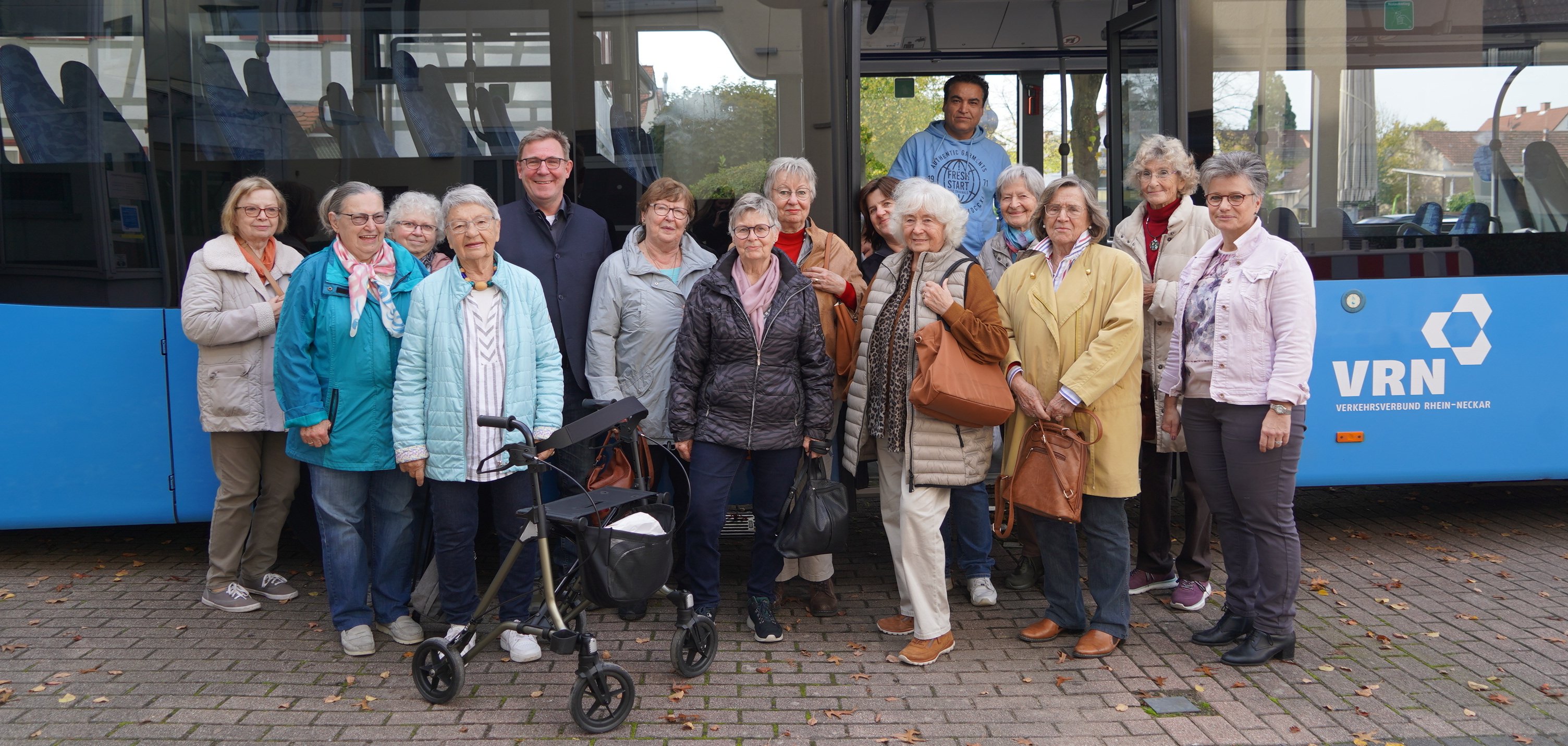 Die Teilnehmenden sowie Ausrichtenden des Mobilitätstrainings stehen in Rimbach vor einem blauen Bus des VGGs.