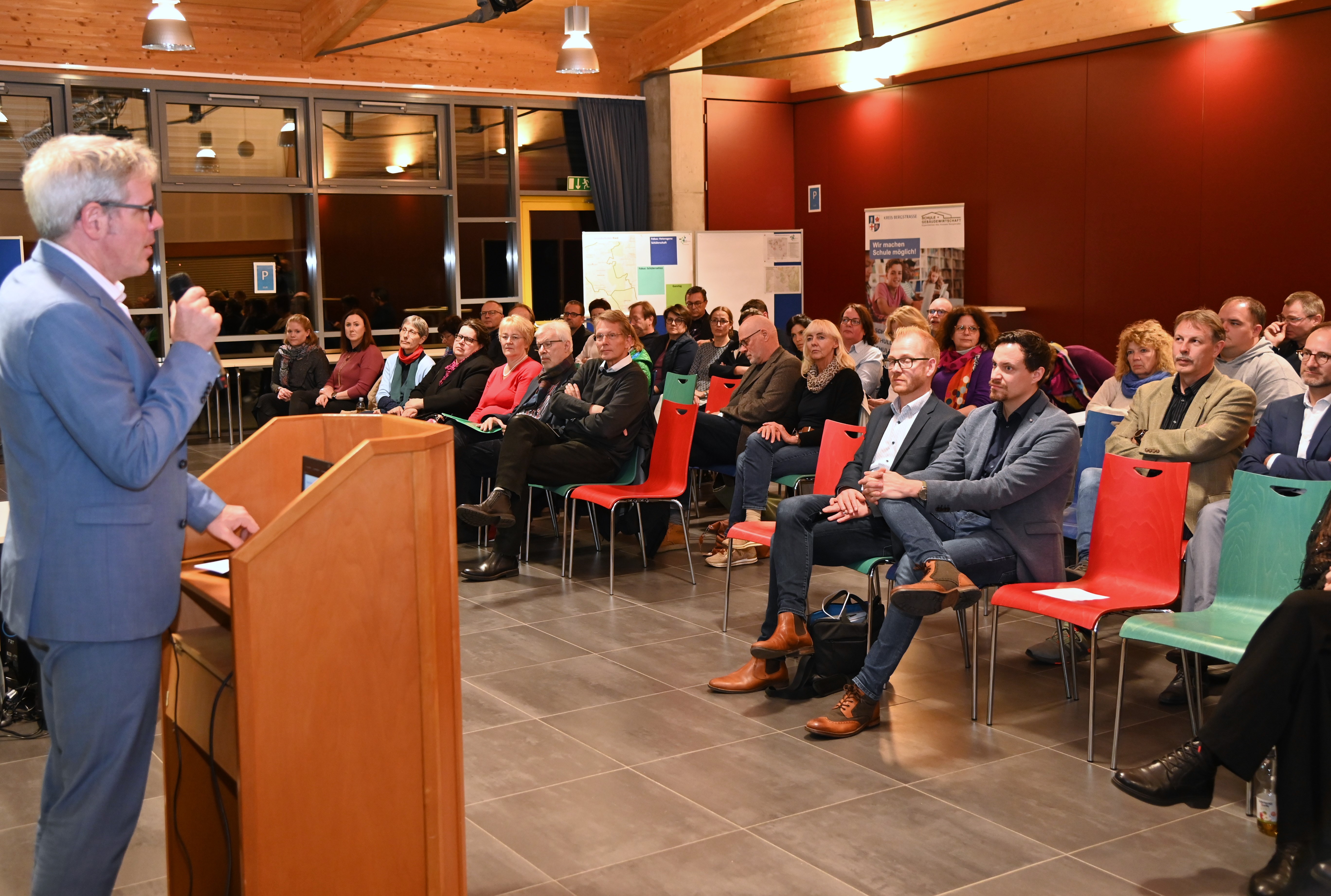 Bei der Regionalkonferenz für das Ried inkl. Viernheim zum Schulentwicklungsplan: Landrat Engelhardt am Podium vor den sitzenden Teilnehmenden.