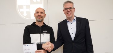 Landrat Christian Engelhardt schüttelt Dietrich Schmidt die Hand, dieser hält seine Urkunde in der Hand.