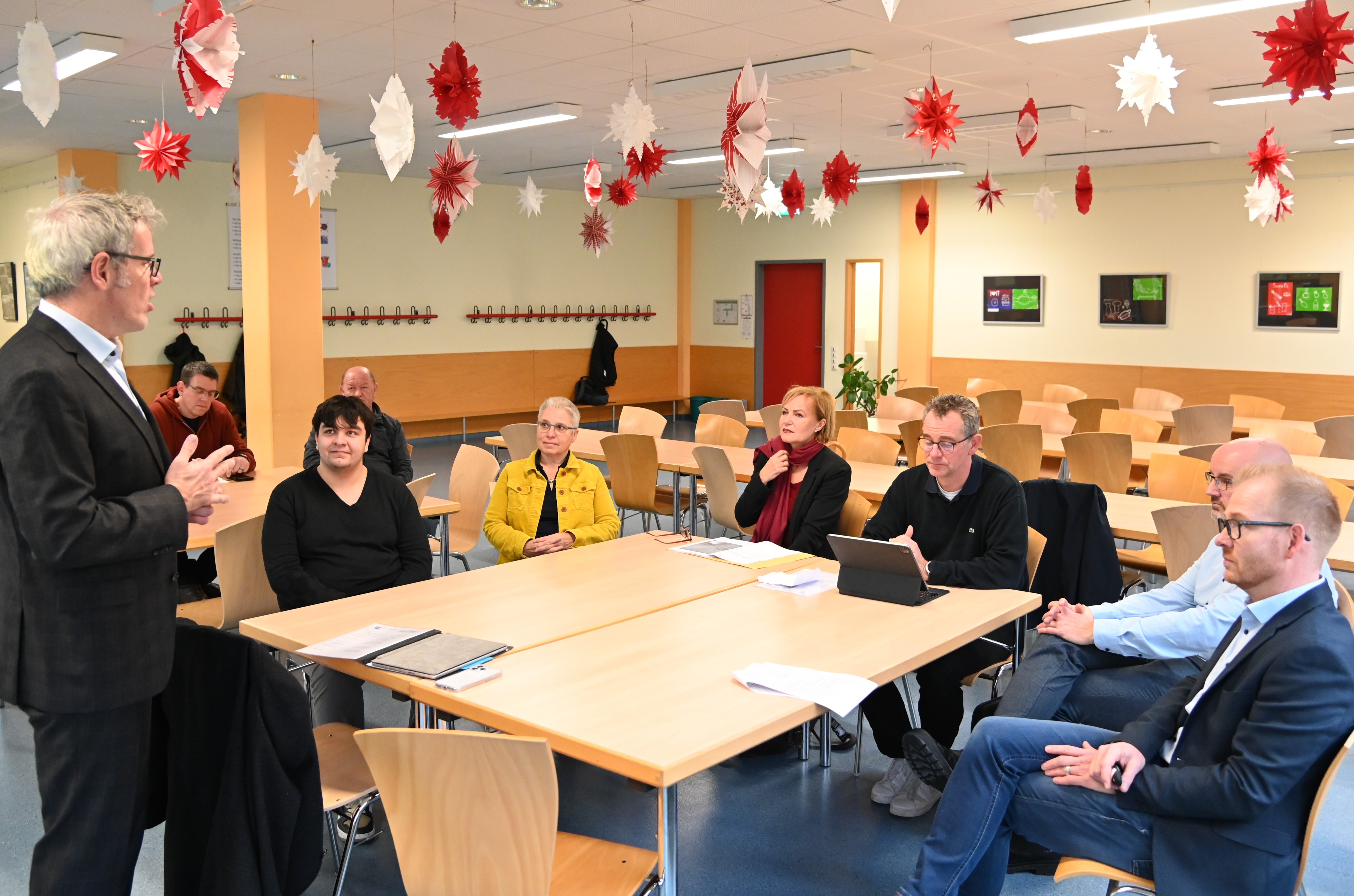 Landrat Christian Engelhardt (l.) stellt gemeinsam mit dem Technischen Betriebsleiter des Eigenbetriebes Schule und Gebäudewirtschaft Johannes Kühn (r.), der Schulgemeinde der Werner-von Siemens-Schule mit Schulleiter Alexander Böhm (2.v.r.), Bürgermeister Christian Schönung (3.v.r.), Schulamtsleiterin Susann Hertz (3. v. r.) und der Schulleiterin der Wingertsbergschule, Jutta Rothfritz, (2.v.r.) die Baupläne für die neue Grundschule in Lorsch vor.