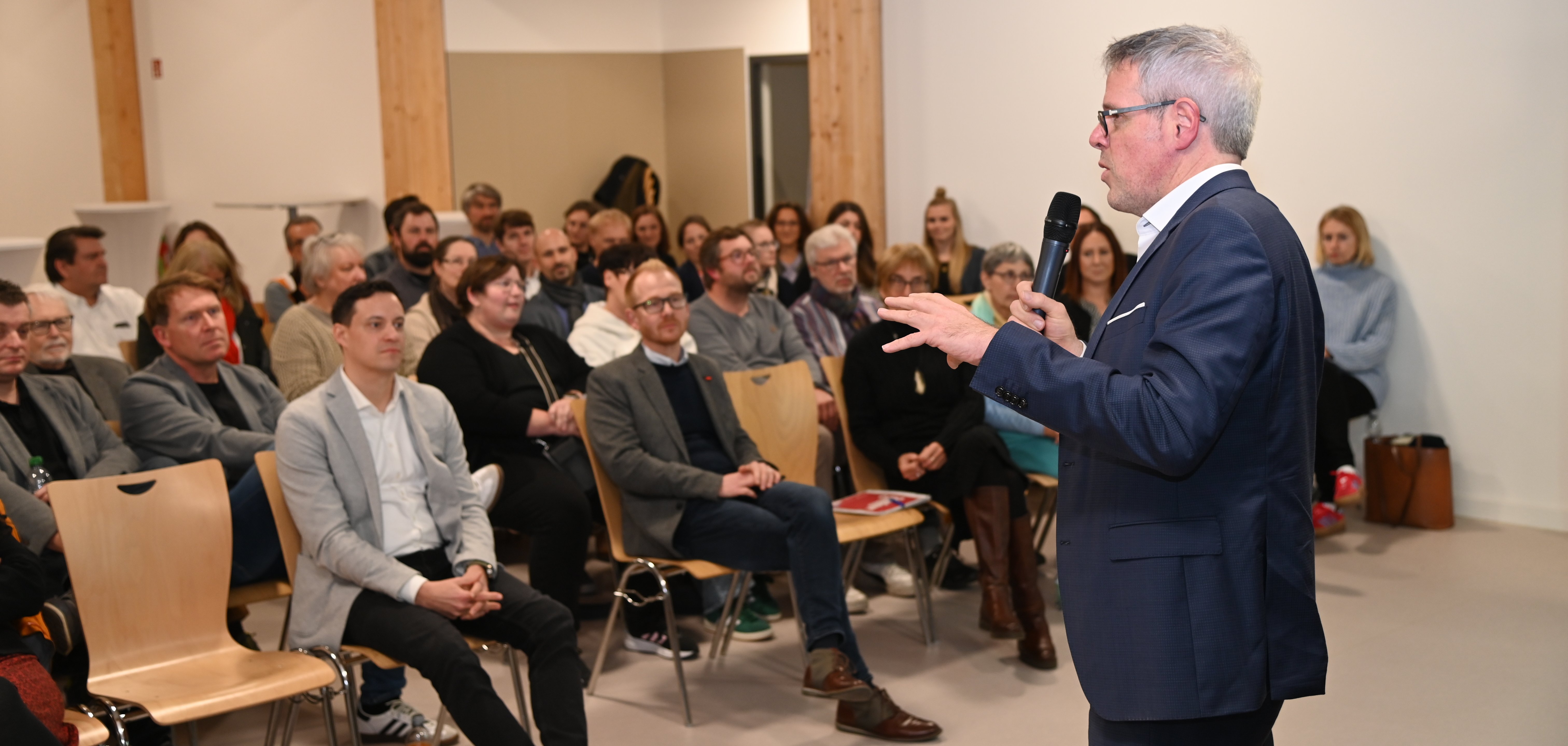 Landrat Engelhardt erläutert vor einem Publikum die Herausforderung zur Entwicklung der Schulstandorte und die Bedeutung des Schulentwicklungsplans.