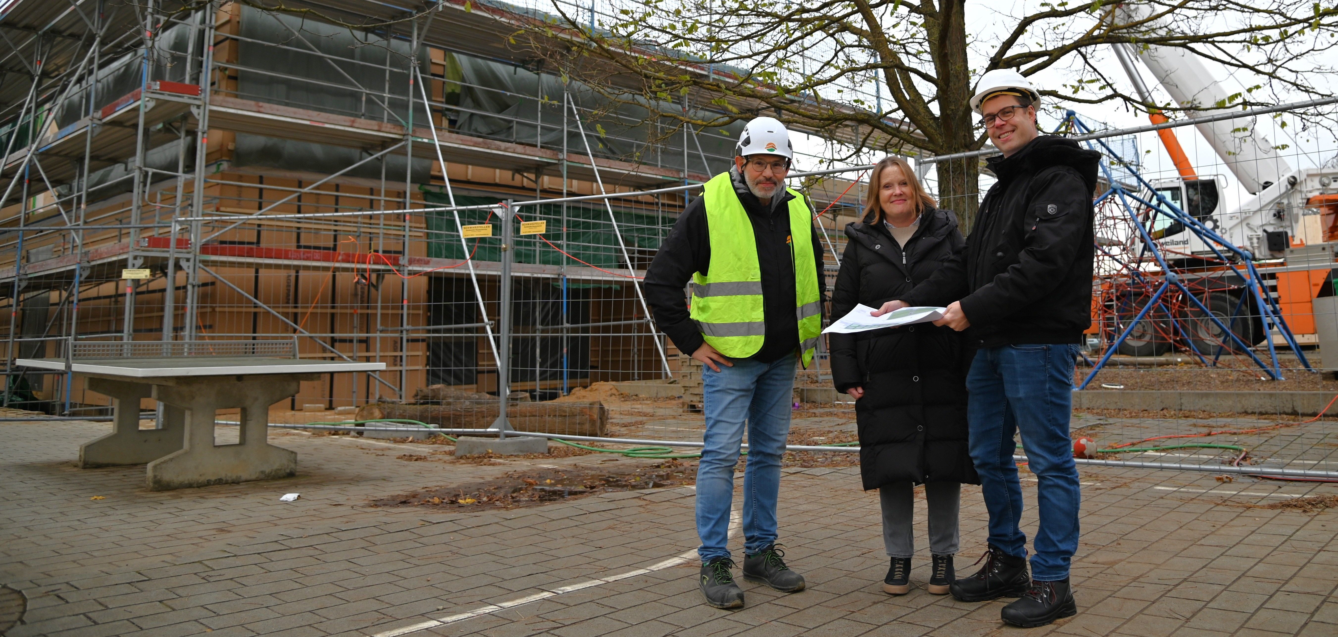 Der Bauleiter der Blumer-Lehmann AG, Werner Hausen, die Schulleiterin Michaela Ohse-Beck und der Projektleiter sowie Mitarbeiter des Eigenbetriebs Schule und Gebäudewirtschaft Daniel Horn (v.l.n.r.) besichtigen gemeinsam die Baustelle.