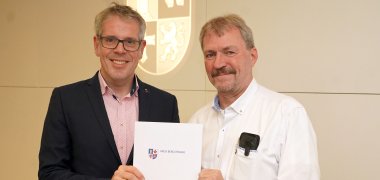 Landrat Christian Engelhardt (li.) überreicht Thomas Fuckner seine Urkunde zur Verabschiedung aus dem Ehrenbeamtenverhältnis als Leitender Notarzt für den Kreis Bergstraße.