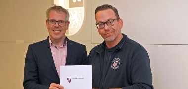 Landrat Christian Engelhardt (li.) überreicht Jörg Weber, Sachbearbeiter in der Abteilung Gefahrenabwehr der Bergsträßer Kreisverwaltung, seine Ernennungsurkunde zum Ehrenbeamten als Organisatorischer Leiter Rettungsdienst im Kreis Bergstraße.